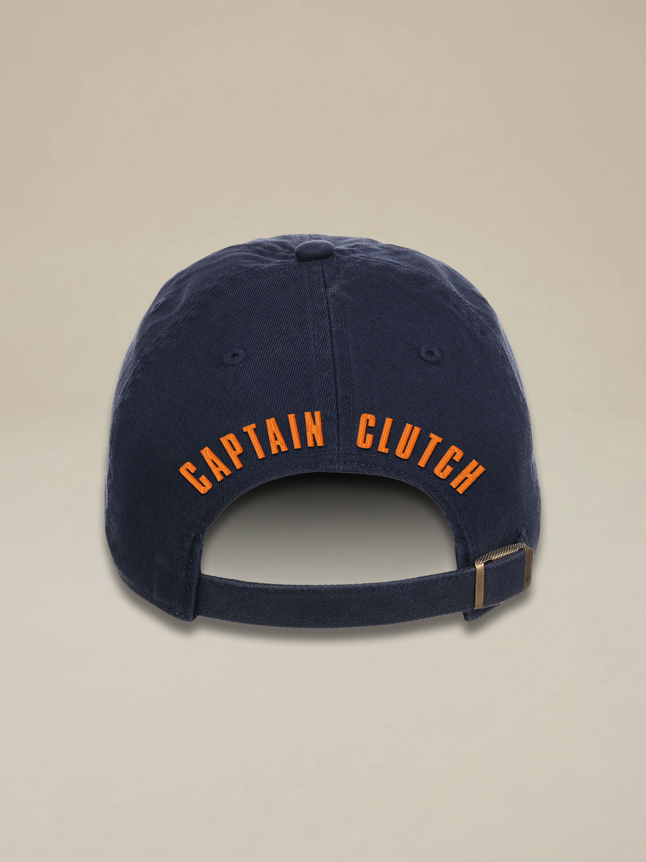 Blue hat with "Captain Clutch" text against a beige background