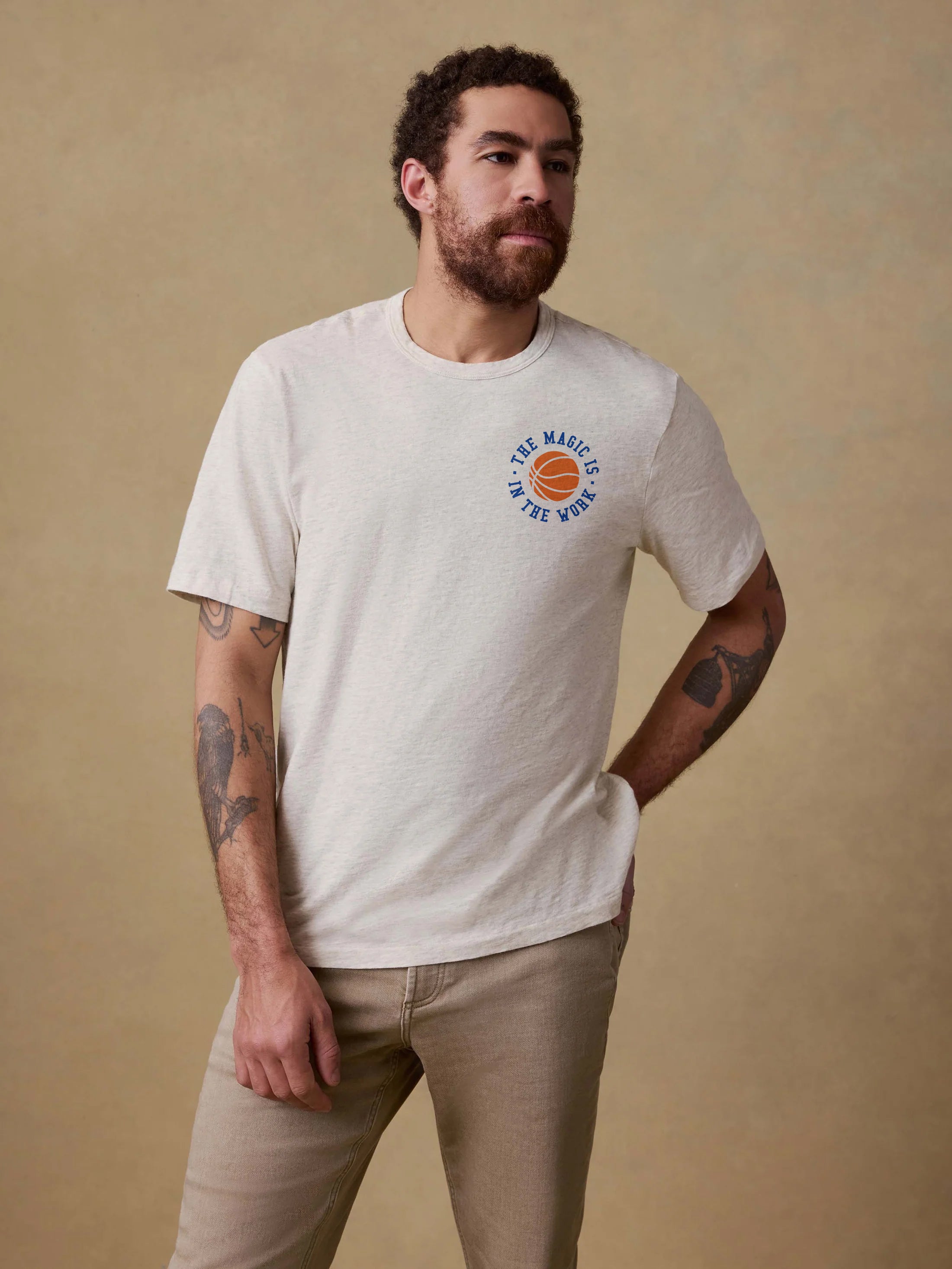 Man wearing a white t-shirt with a Jalen Brunson graphic design on the left chest against a beige background