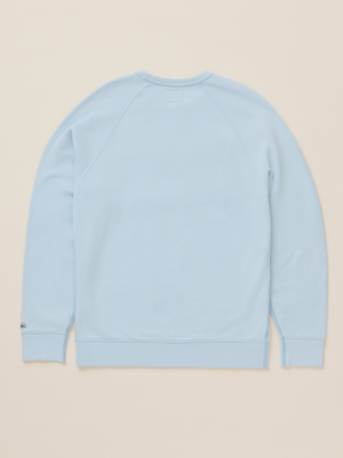 A light blue crewneck sweatshirt shown from the back, laid flat against a solid beige background., image 7 of 7