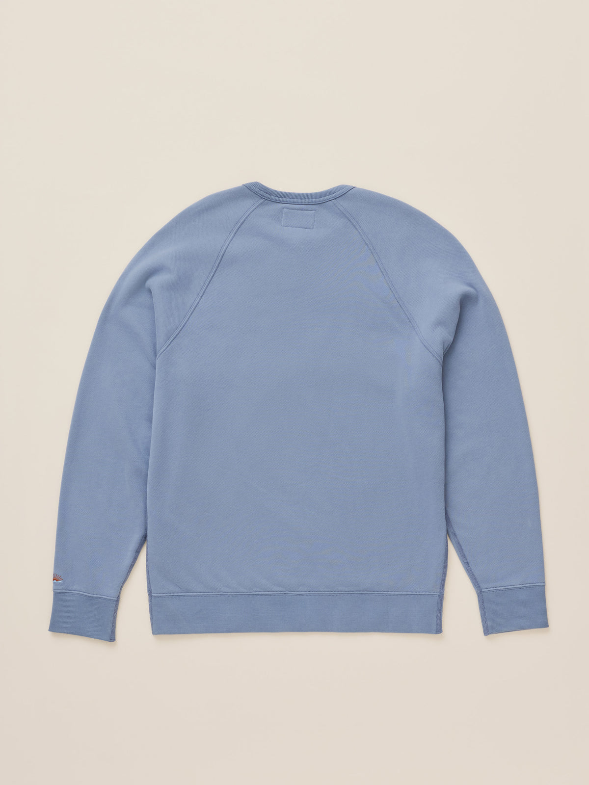 A light blue crewneck sweatshirt shown from the back, laid flat on a solid beige background., image 8 of 8