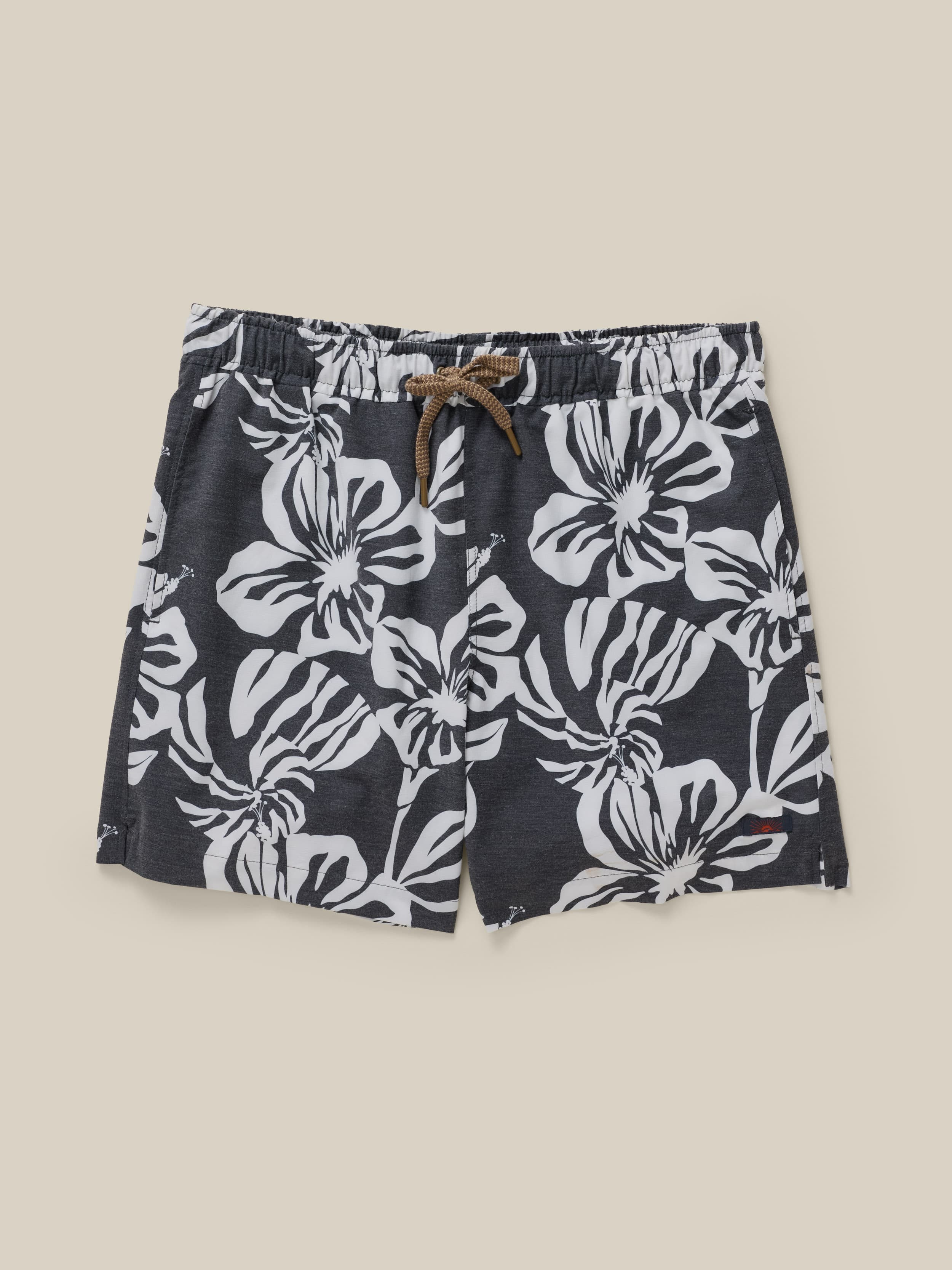 Black shorts with white floral pattern on a beige background