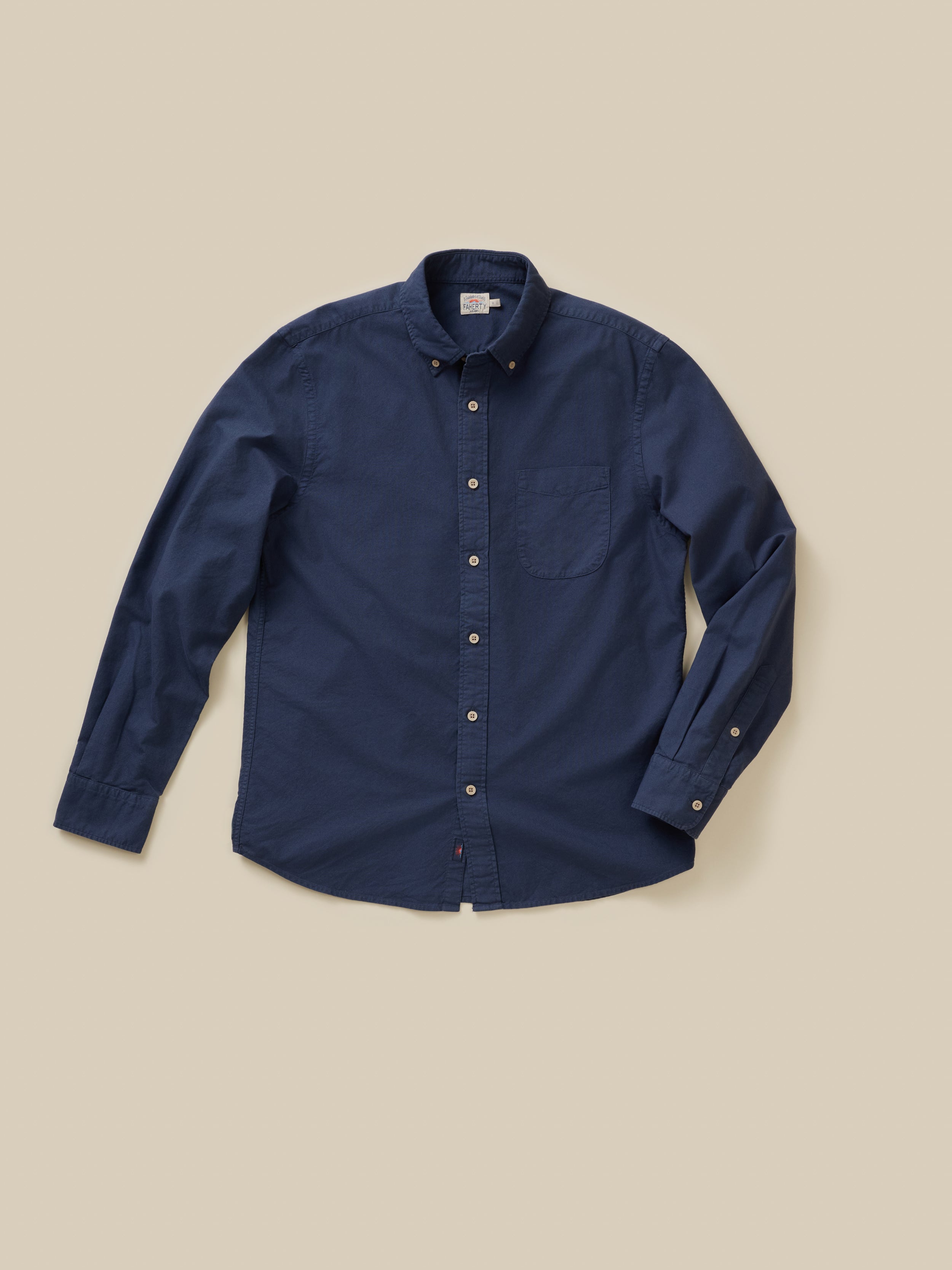 Navy blue button-up shirt on a beige background