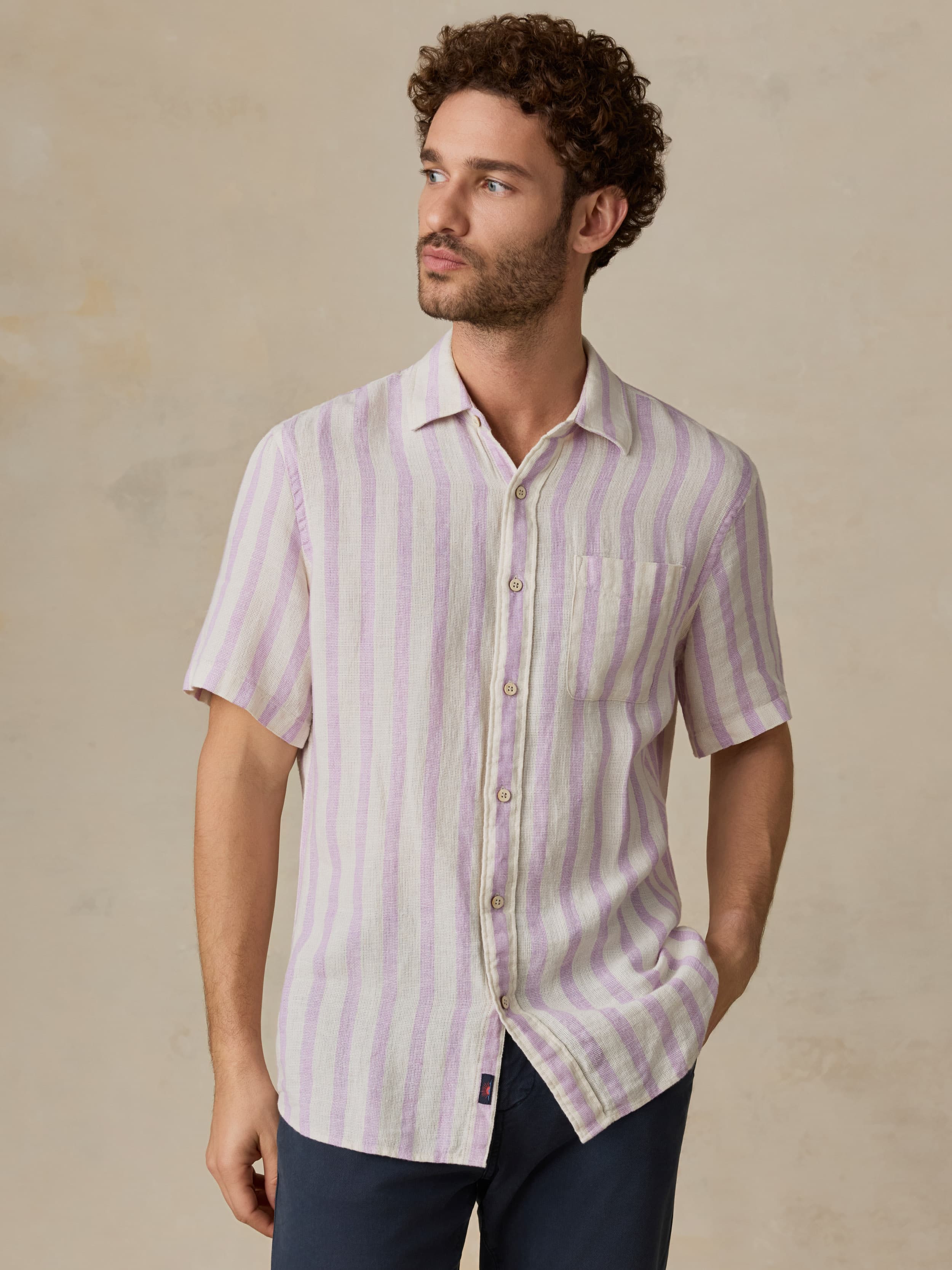 Man wearing a light purple striped shirt against a beige background