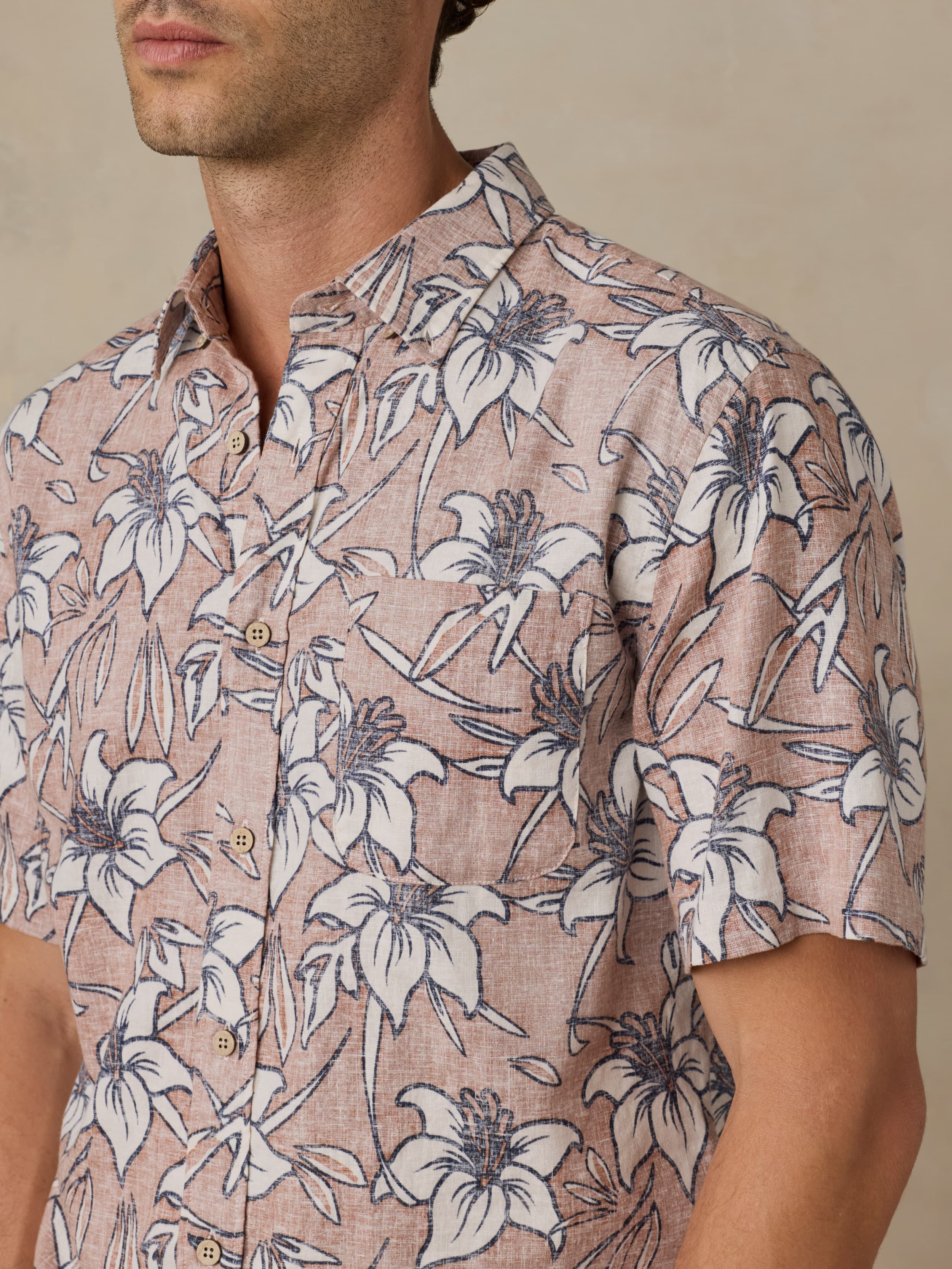Man wearing a floral patterned shirt against a neutral background