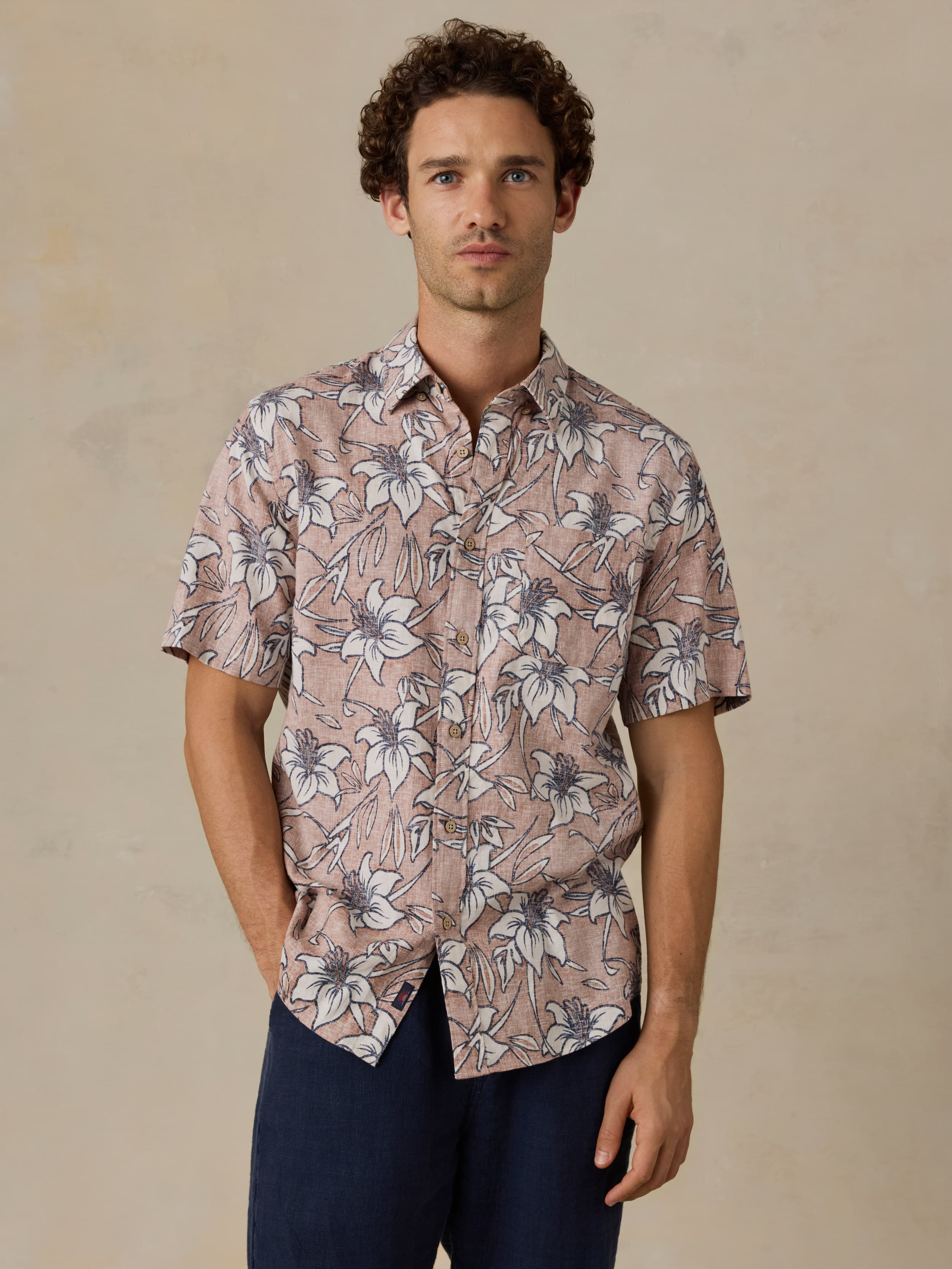 Man wearing a floral patterned shirt against a beige background