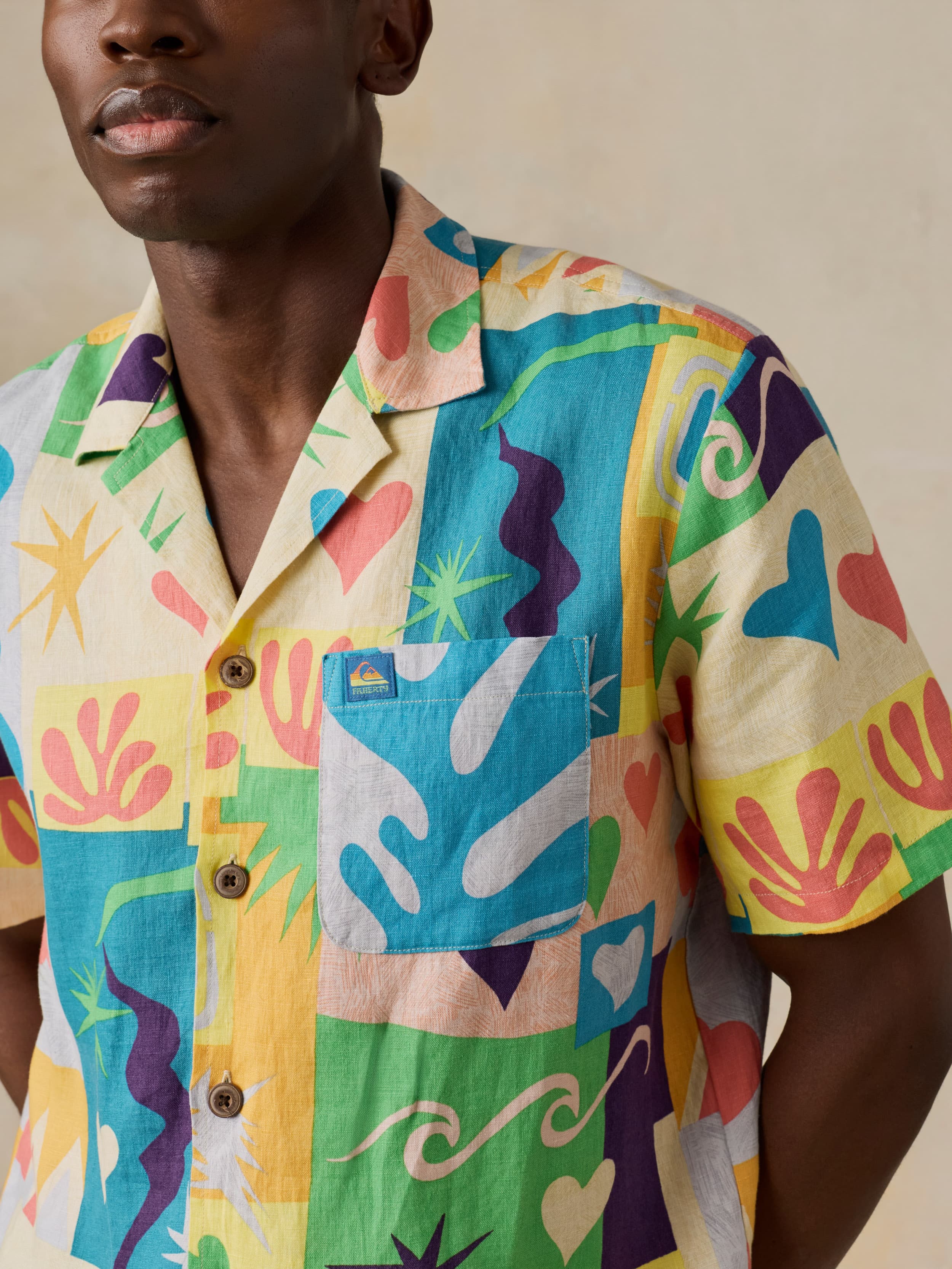 Man wearing a colorful patterned shirt with a beige background