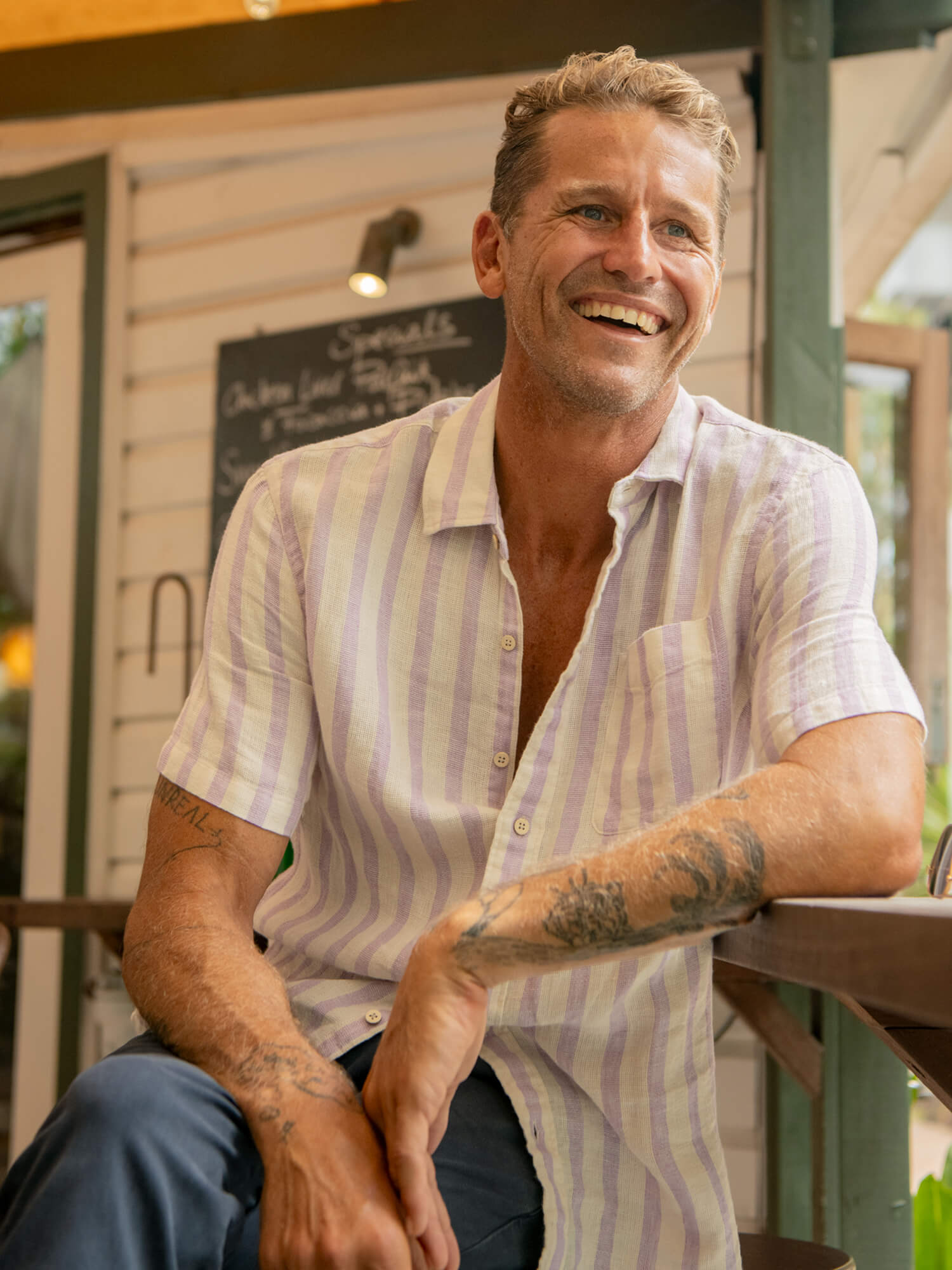 Man wearing a light purple striped shirt and navy pants