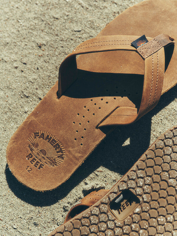 An overhead shot of Faherty X Reef sandals on the beach