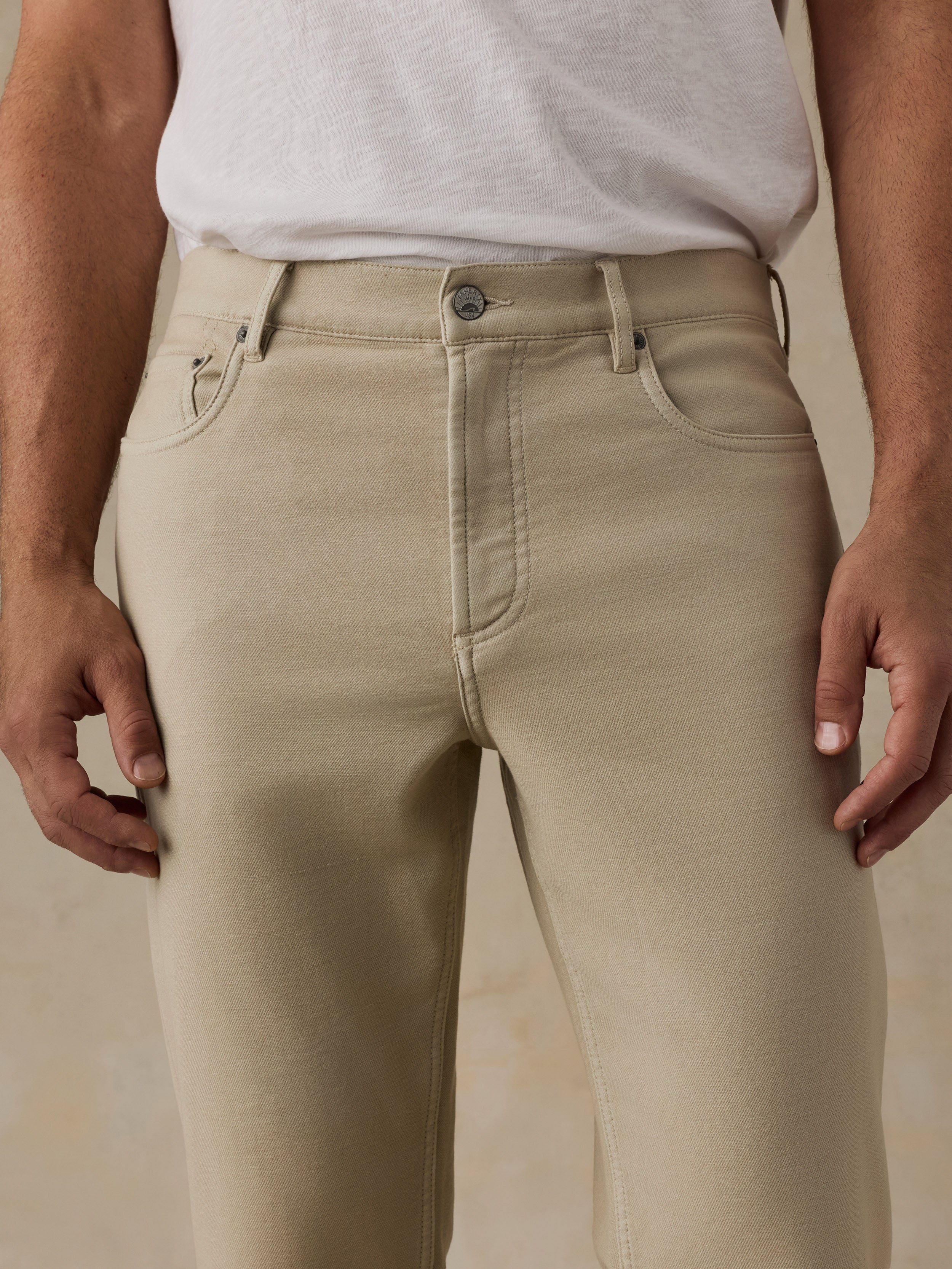 Beige pants worn by a man against a beige background