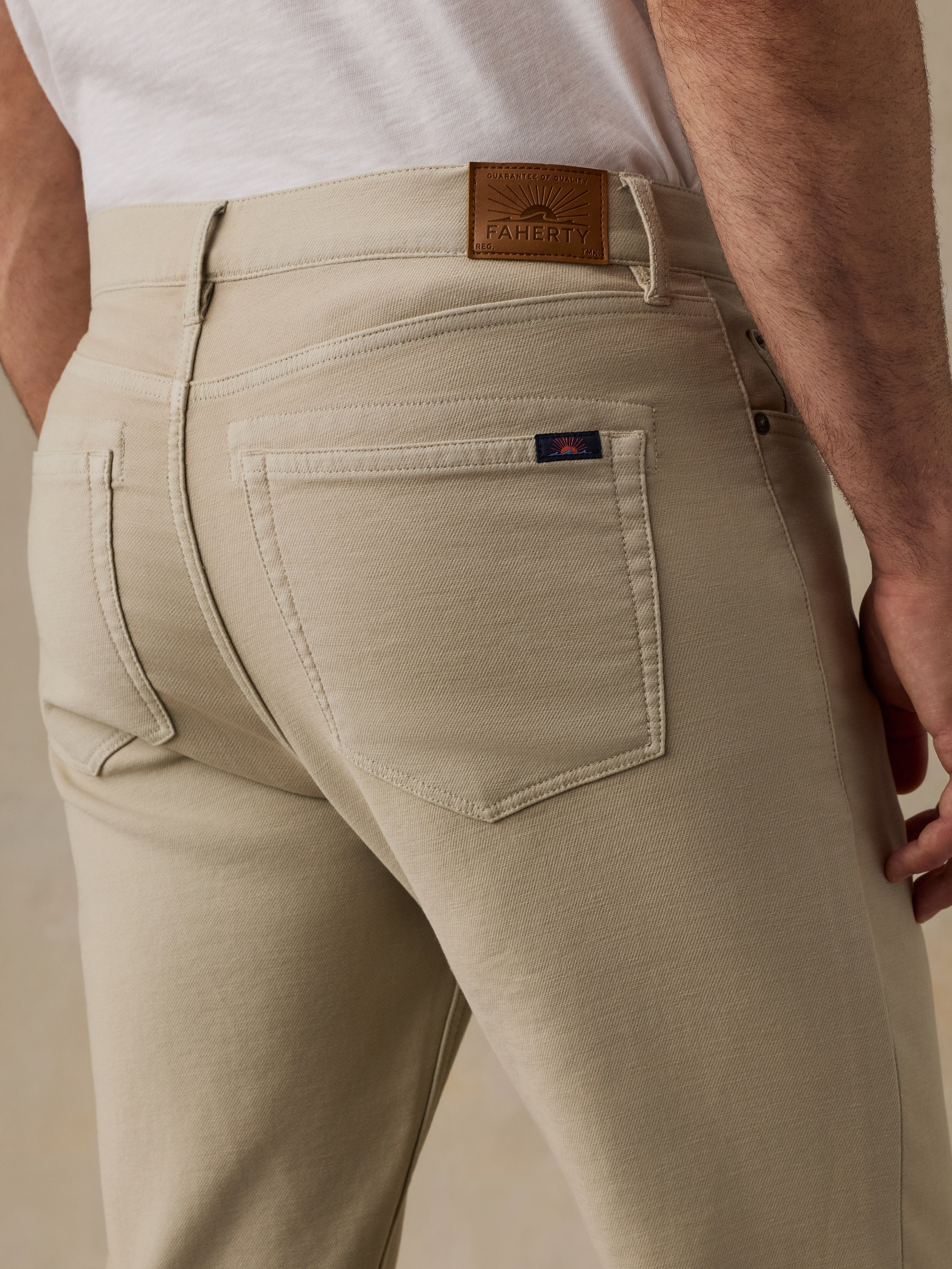 Beige pants with a Faherty brand logo on a beige background