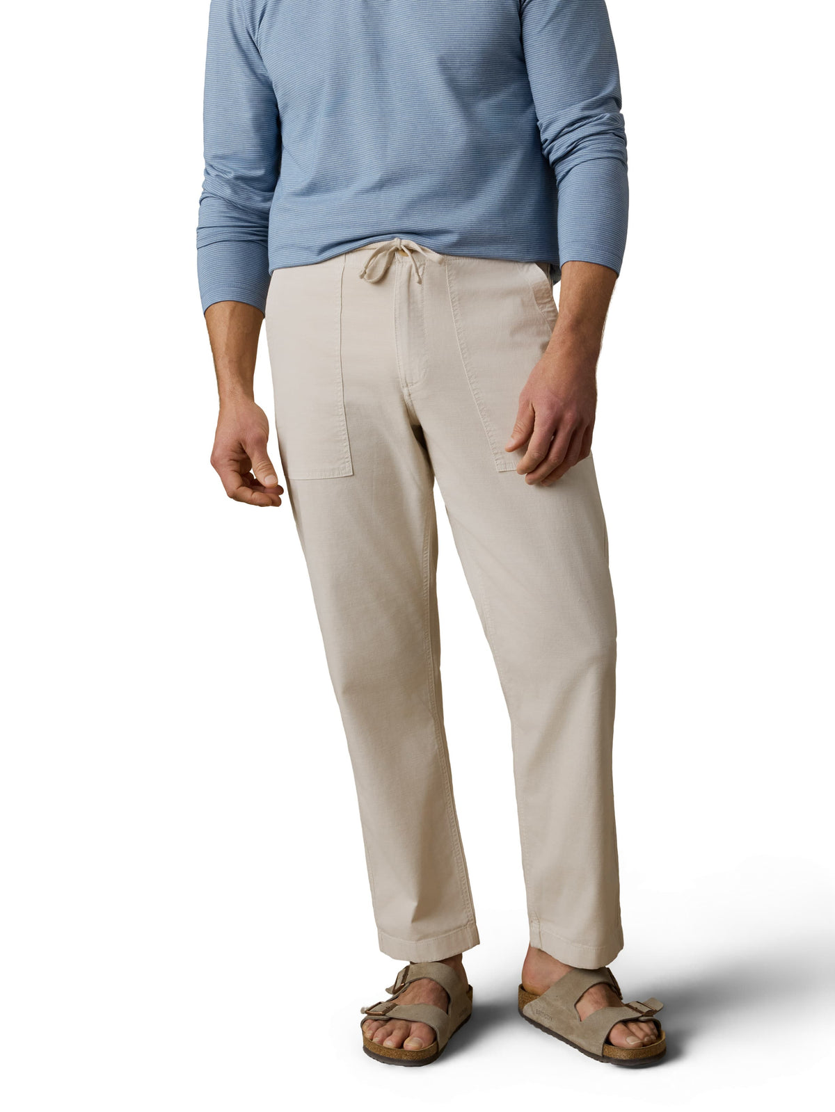 A man wearing a blue polo, beige pants, and birkenstocks, image 2 of 3