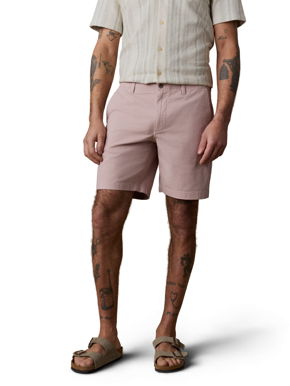 A man wearing a white striped button up shirt, pink pants, and birkenstocks, image 2 of 4