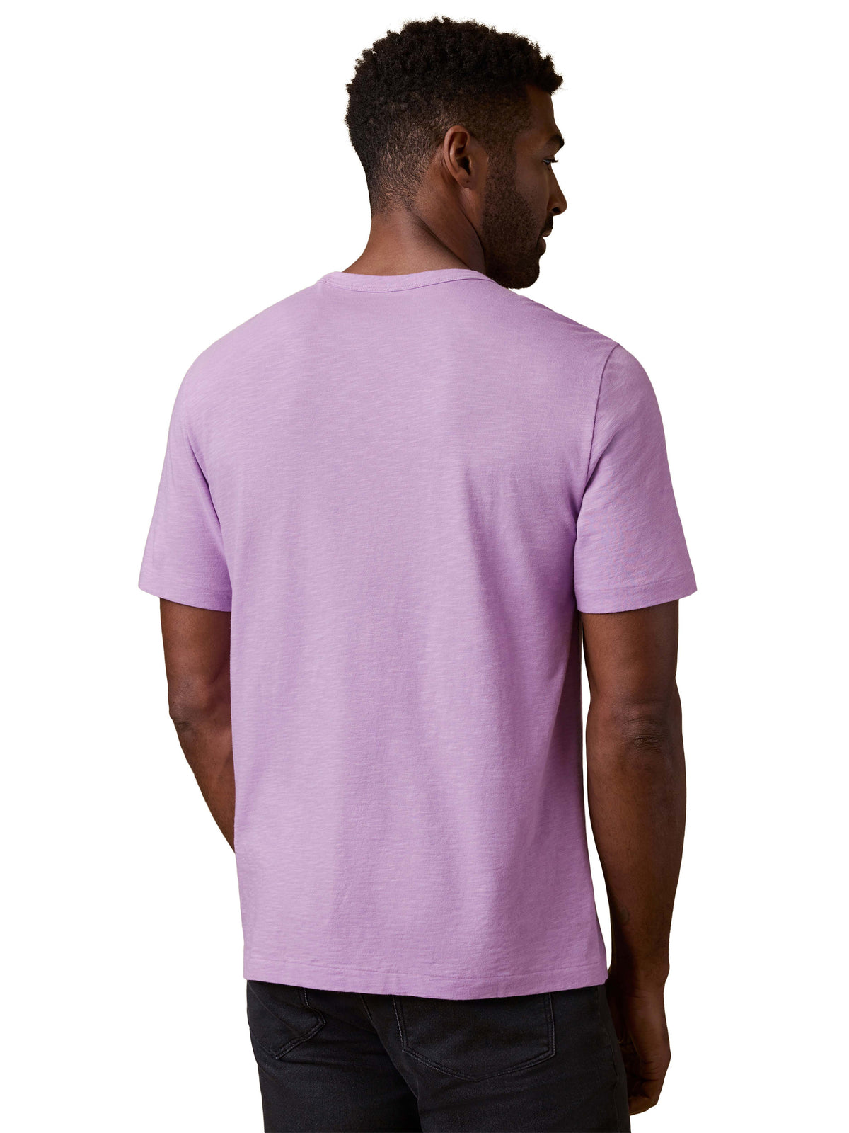 A man viewed from behind wearing a purple tee and black jeans, image 3 of 3