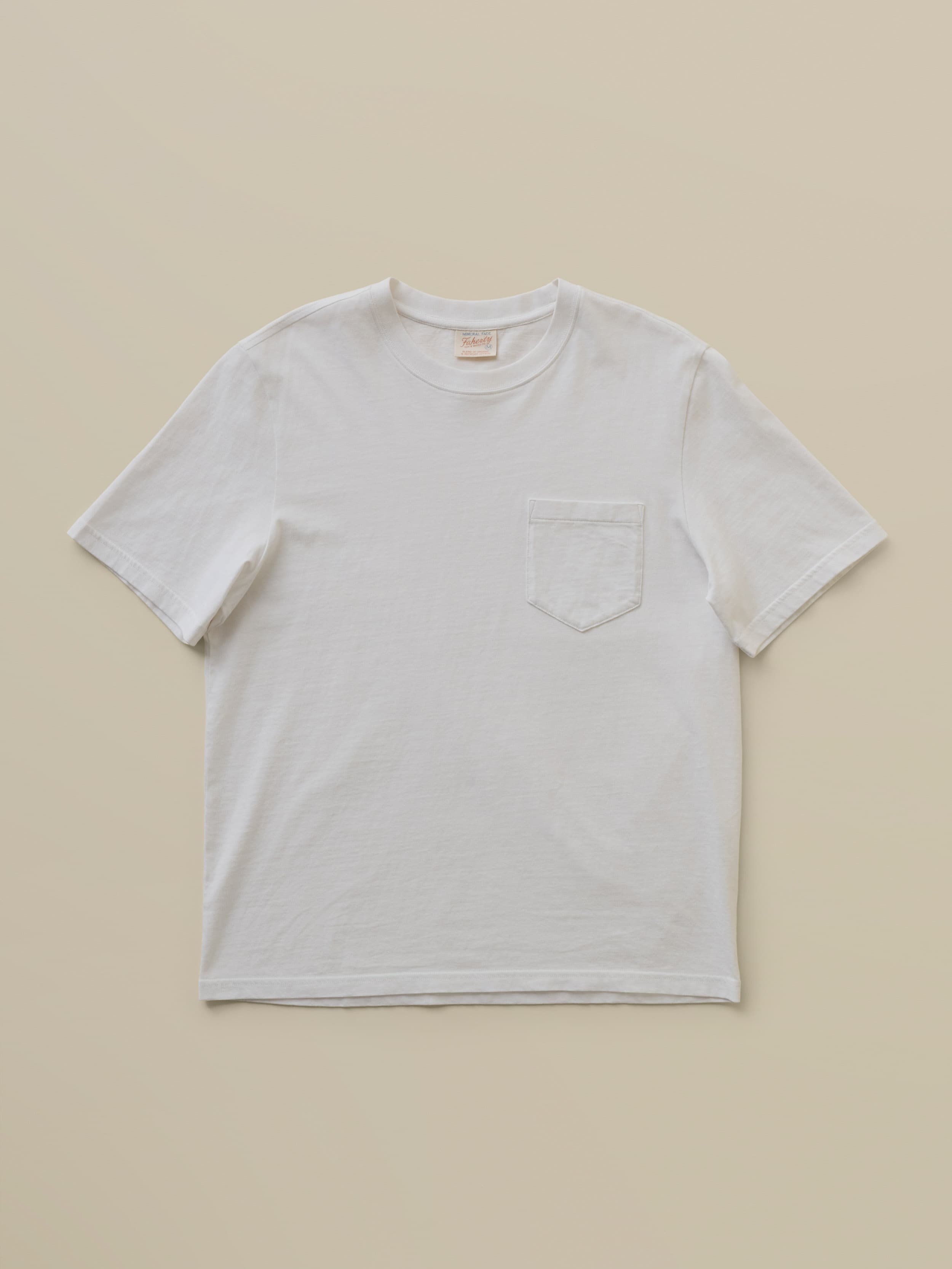 White t-shirt with a pocket on a beige background