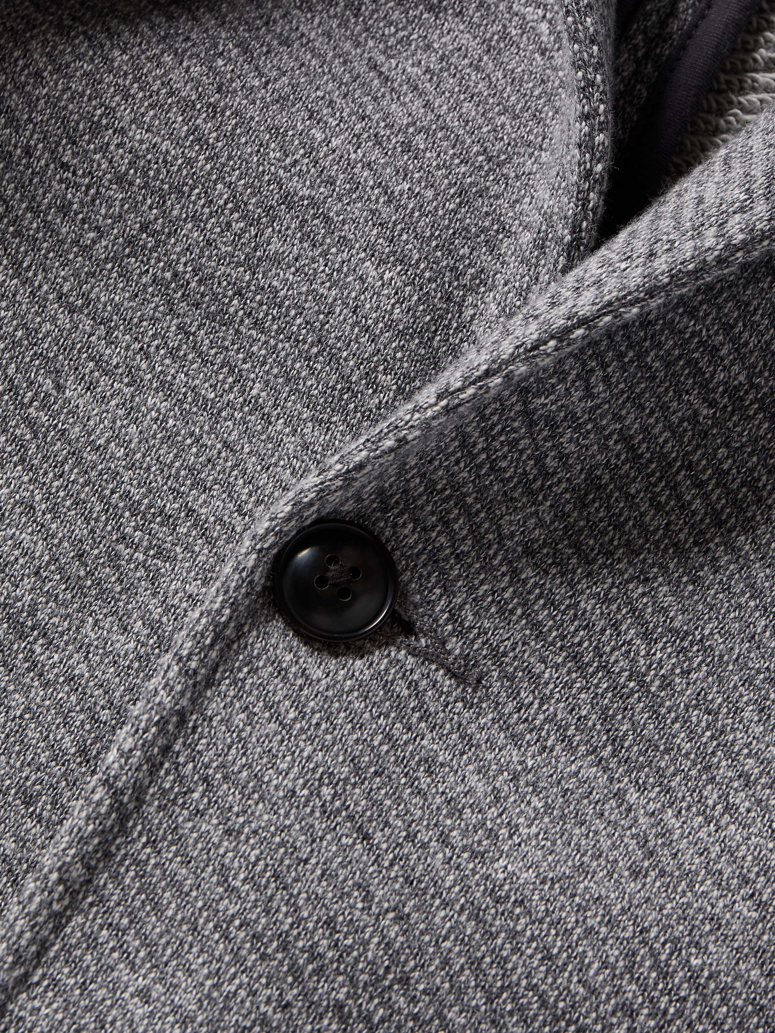 Close-up of a textured gray fabric with a button