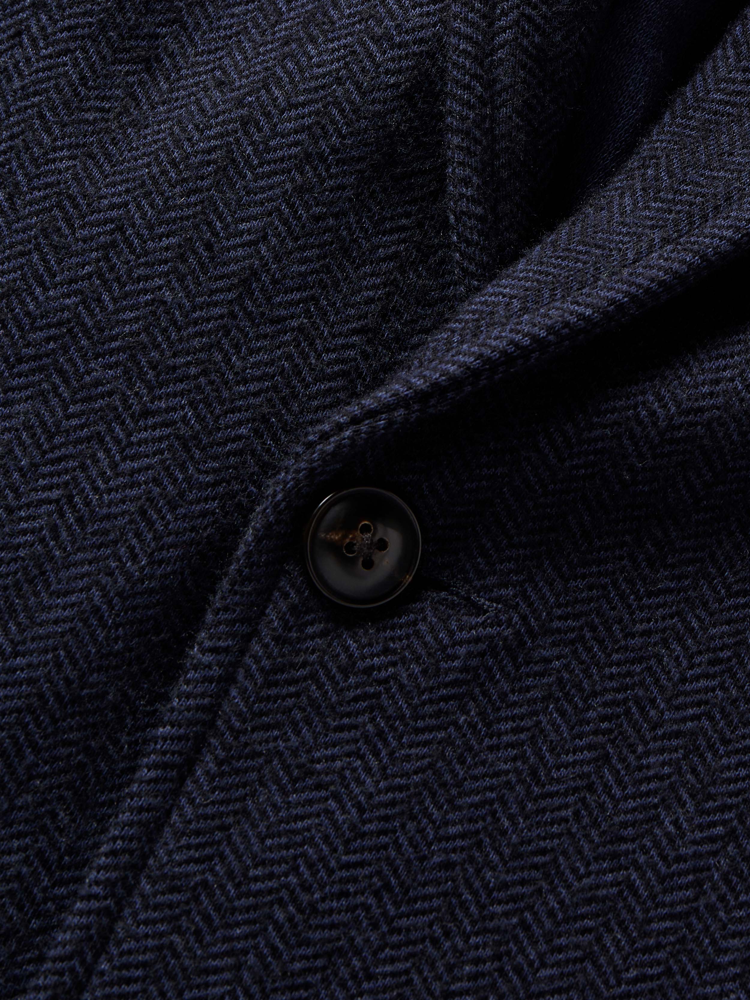 Close-up of a dark blue textured blazer with a button