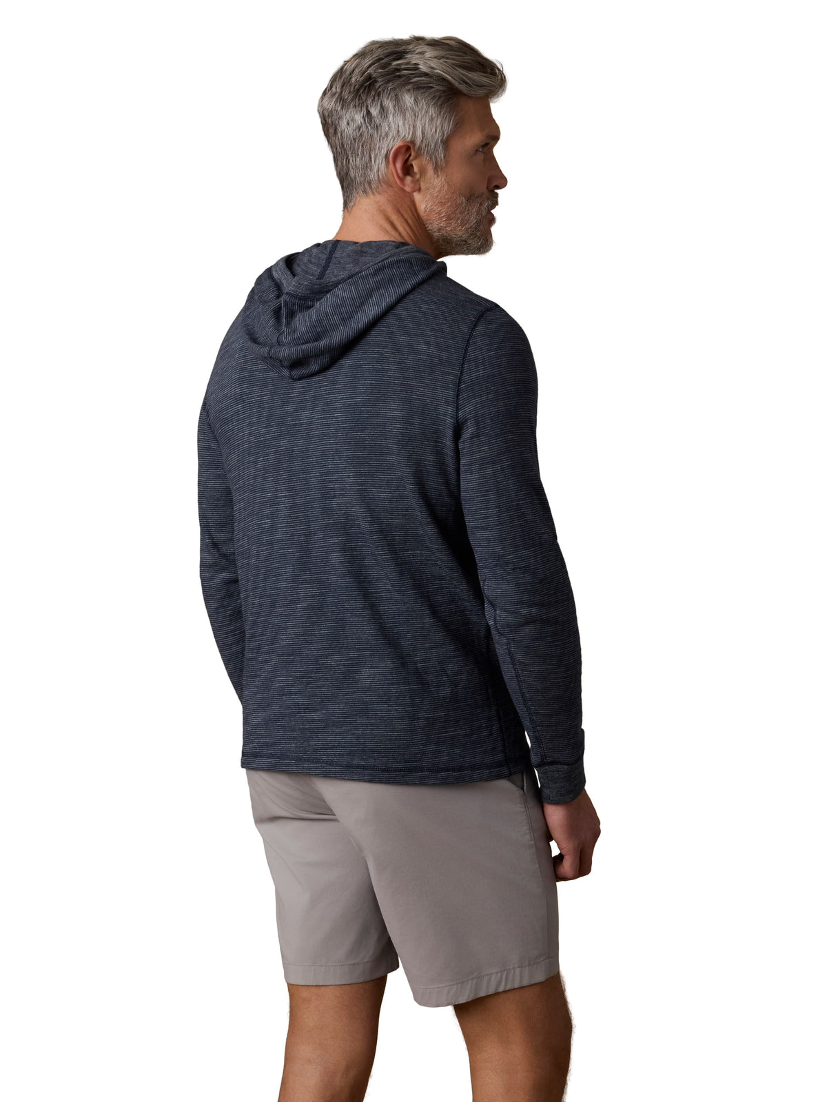 A man viewed from behind wearing a navy hoodie and grey shorts, image 3 of 3