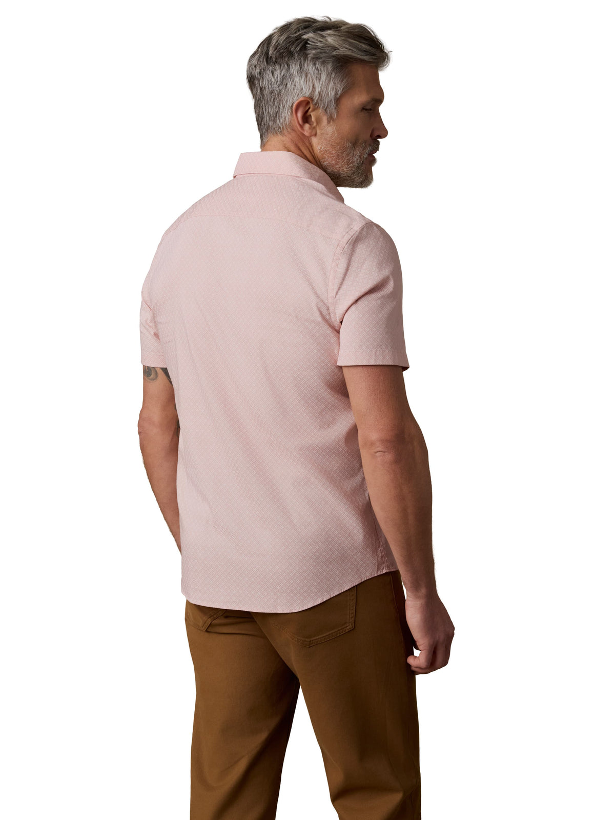 A man viewed from behind wearing a pink button up shirt and brown pants, image 3 of 3