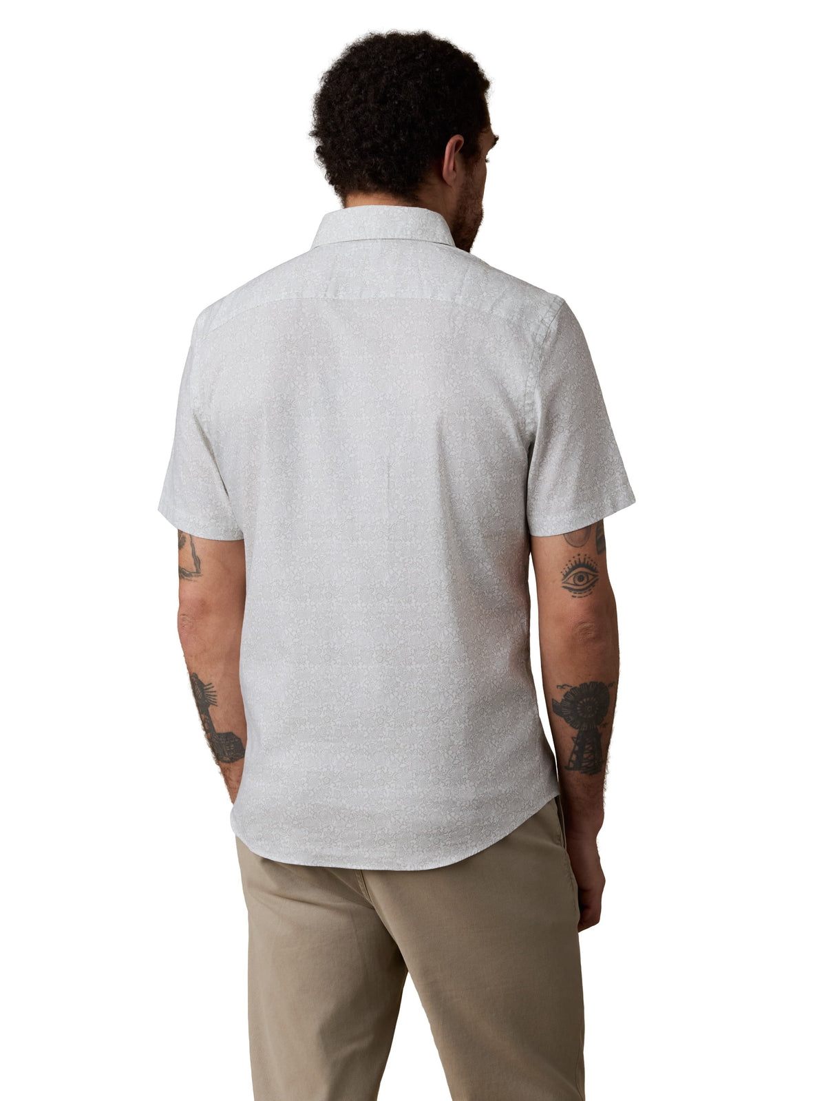 A man viewed from behind wearing a white button up shirt and beige pants, image 3 of 3
