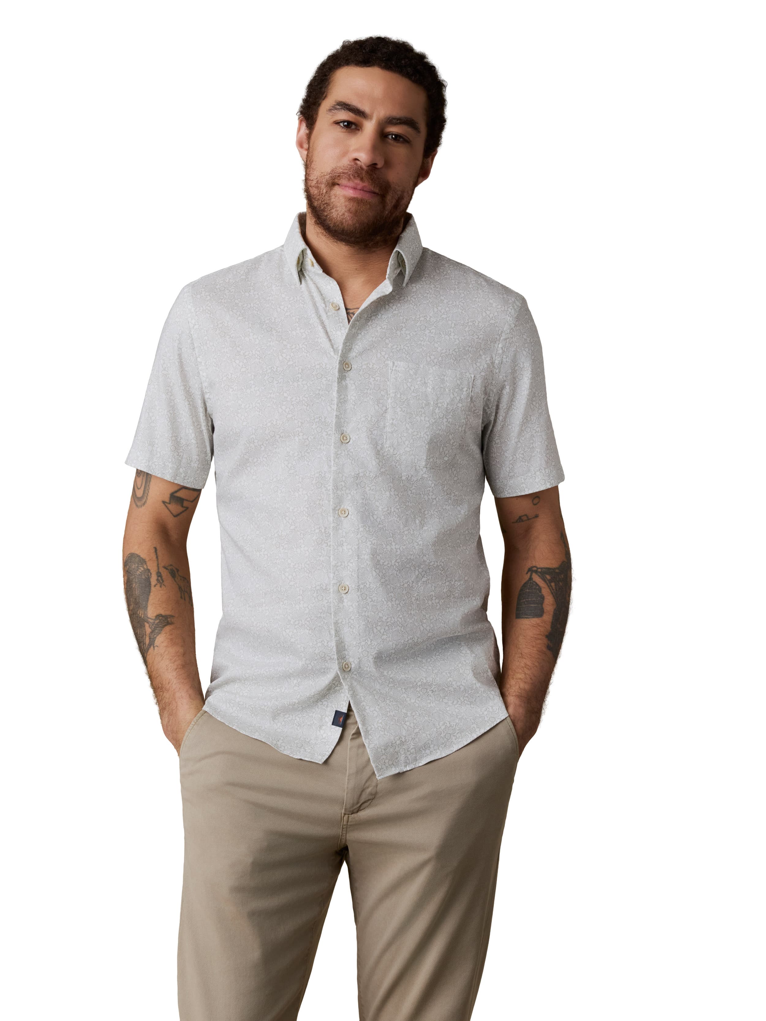 A man wearing a white button up shirt and beige pants