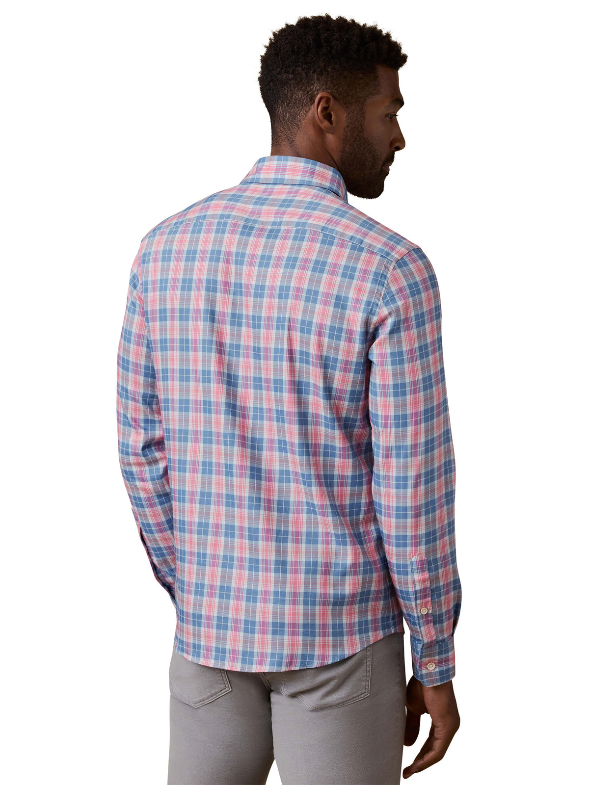 A man viewed from behind wearing a red and blue plaid shirt and grey pants, image 3 of 3
