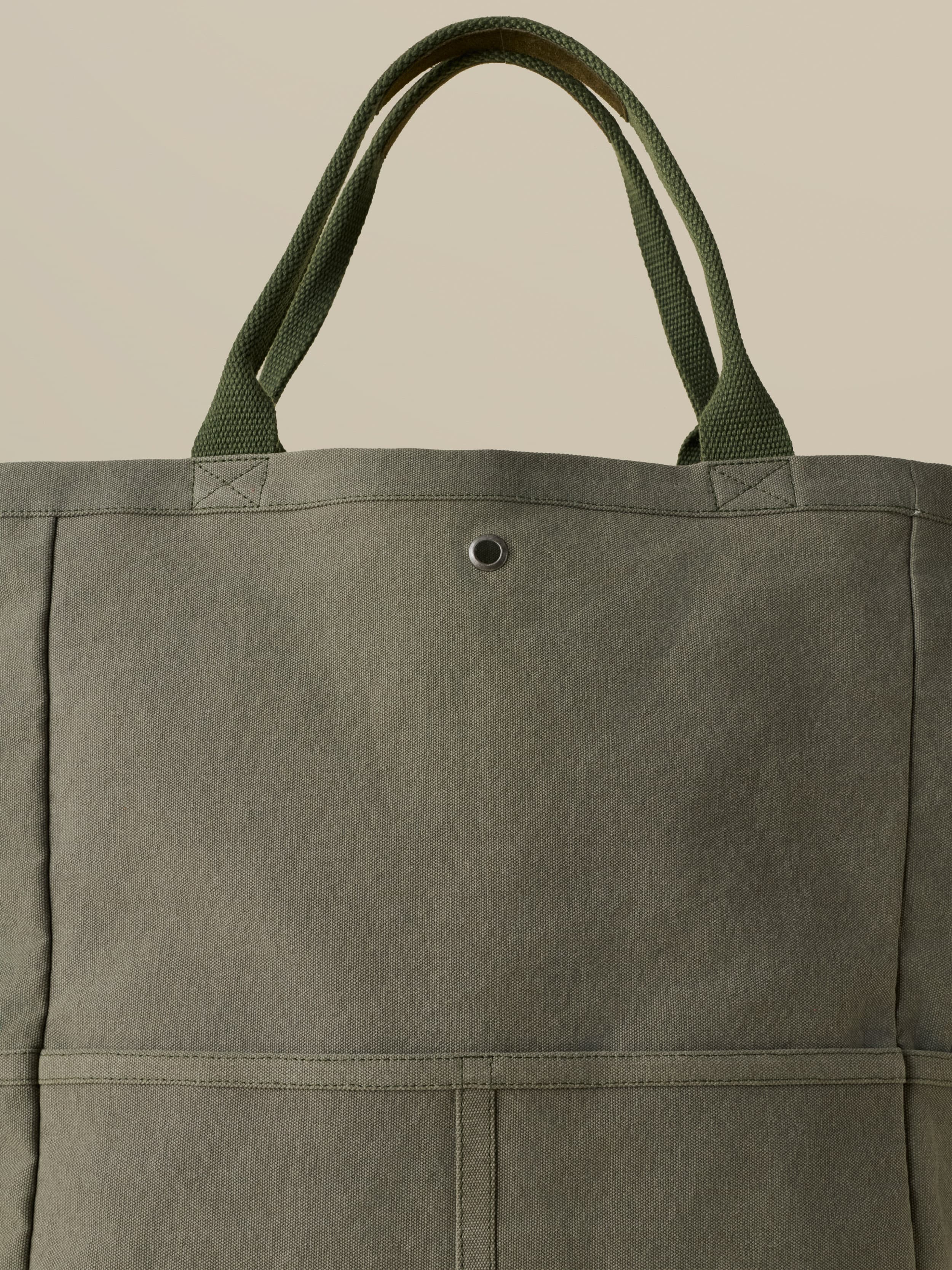 Green tote bag against a beige background