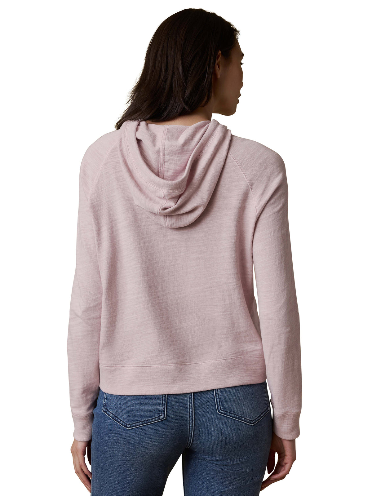 A woman viewed from behind wearing a light purple hoodie and blue jeans, image 3 of 3