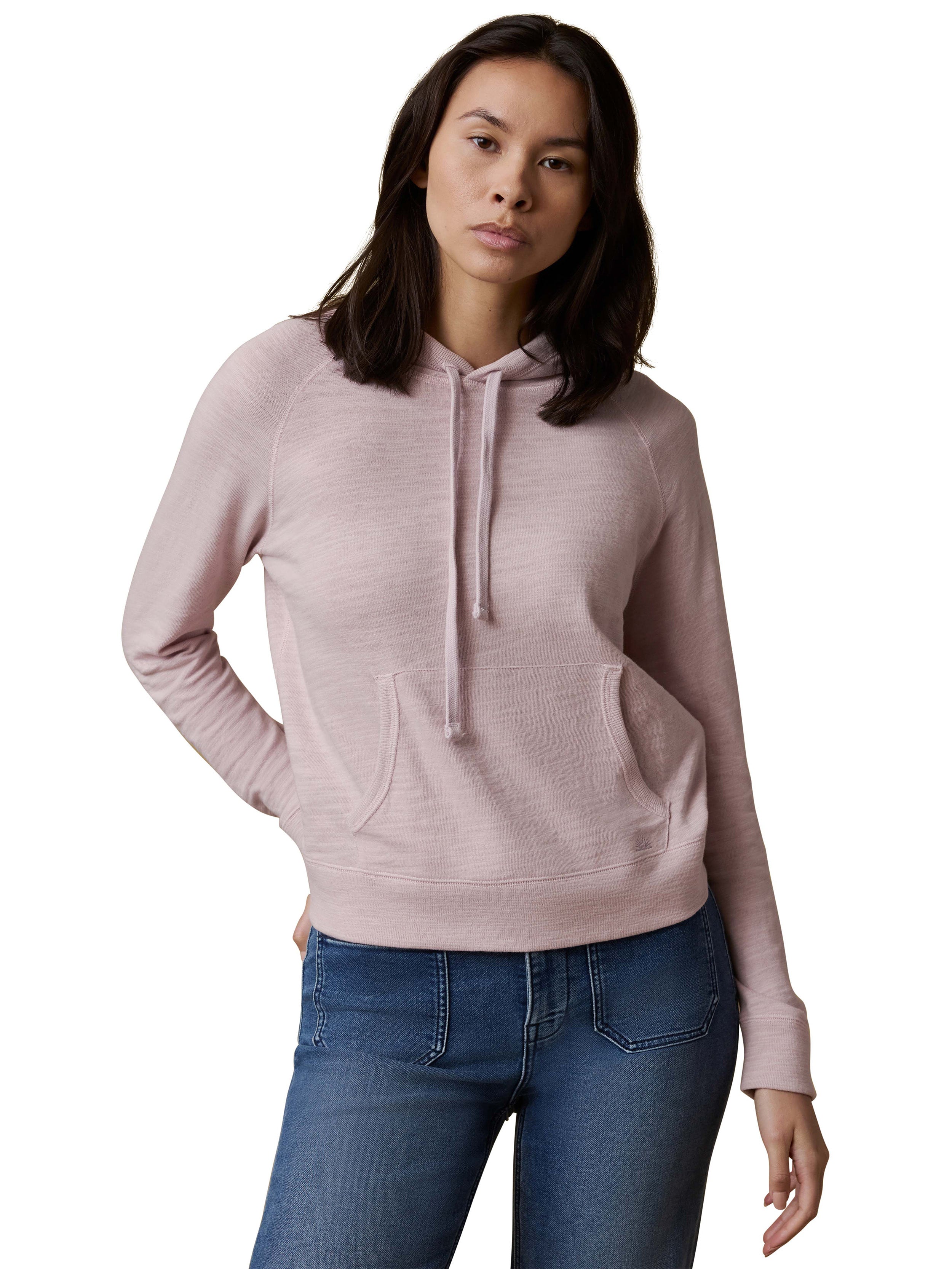 A woman wearing a light purple hoodie and blue jeans