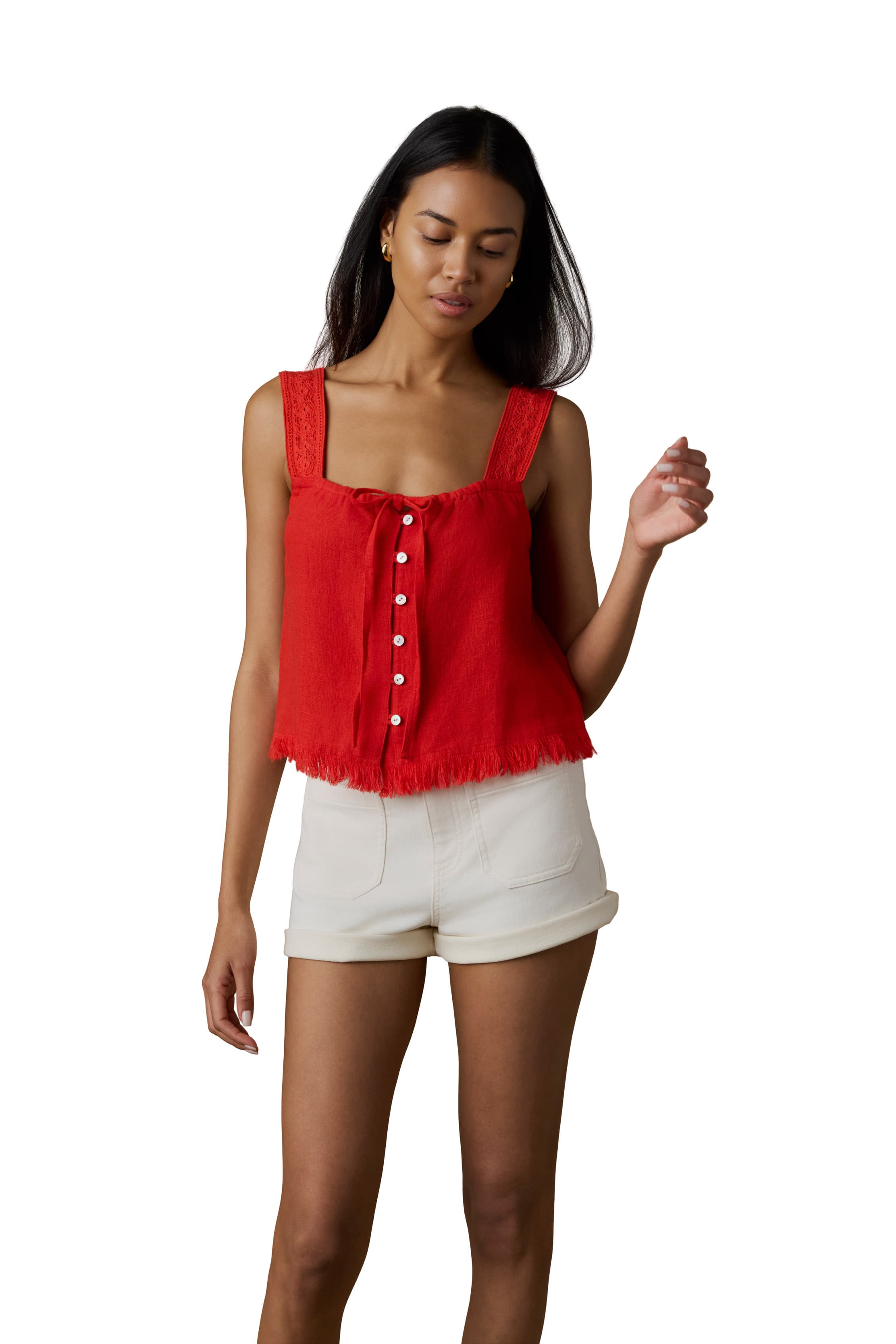 A woman wearing a red tank top and white shorts