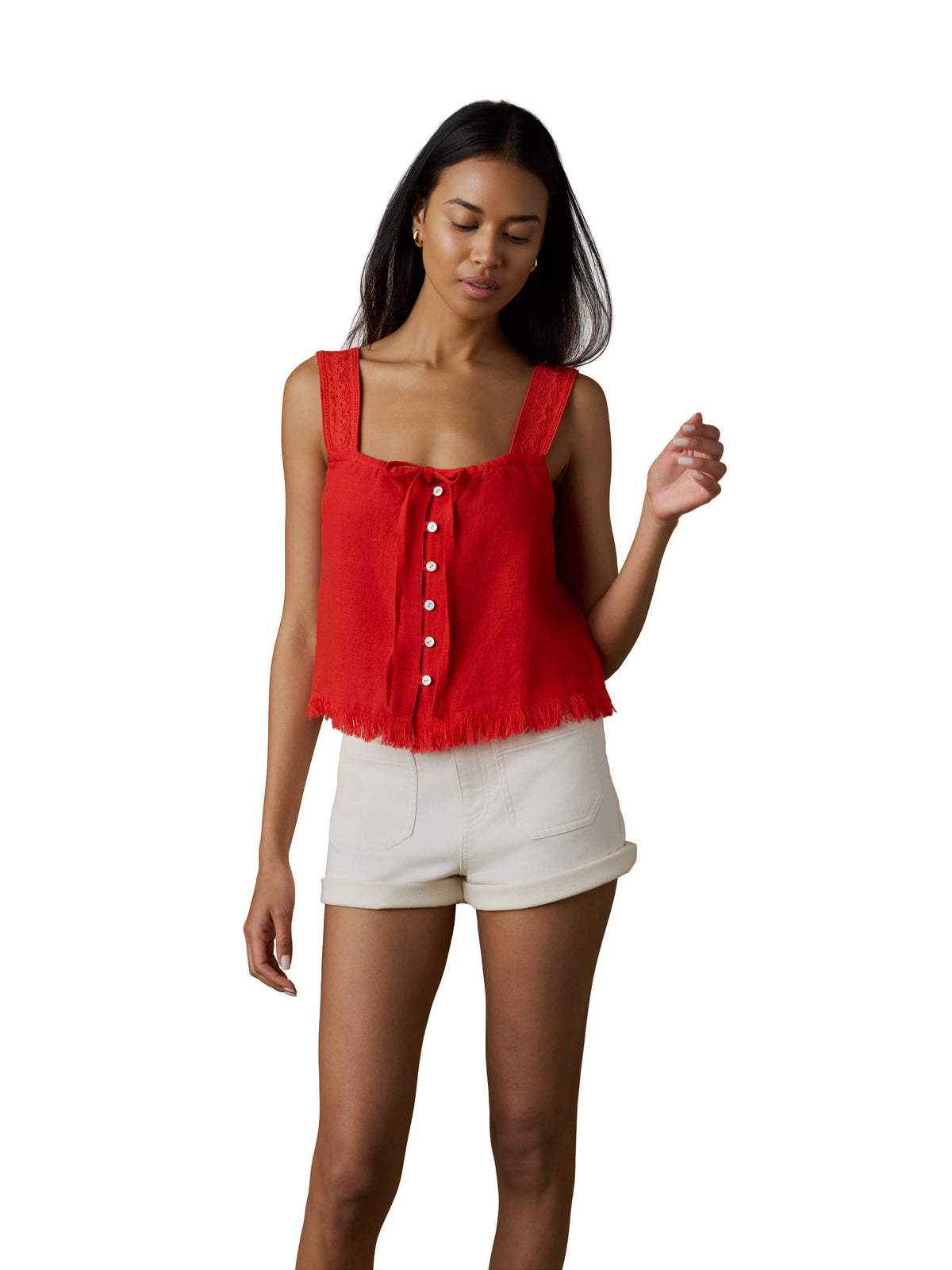 A woman wearing a red tank top and white shorts, image 1 of 5