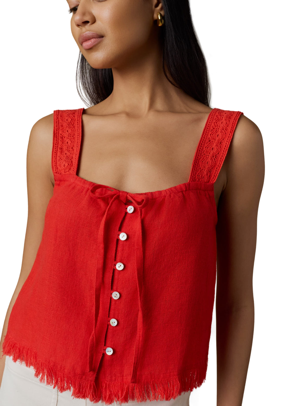 Close up of a woman wearing a red tank top and white shorts, image 4 of 5