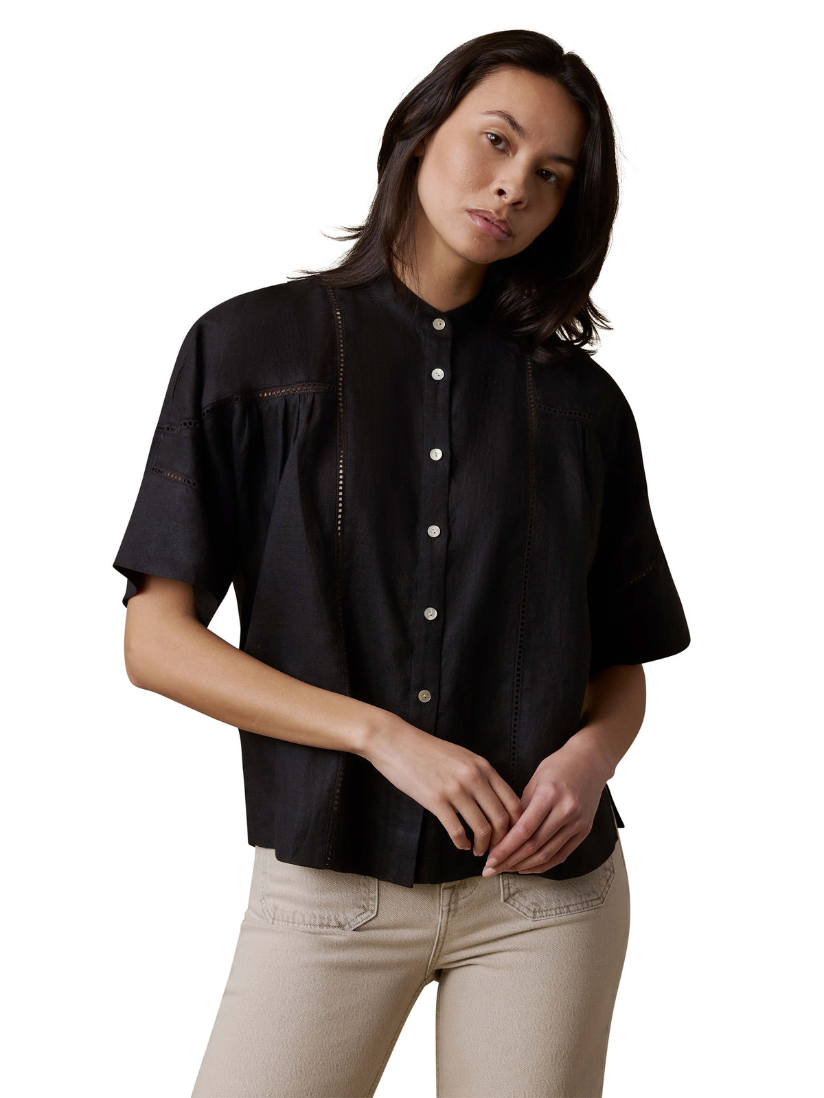 A woman wearing a black shirt and beige pants, image 1 of 3