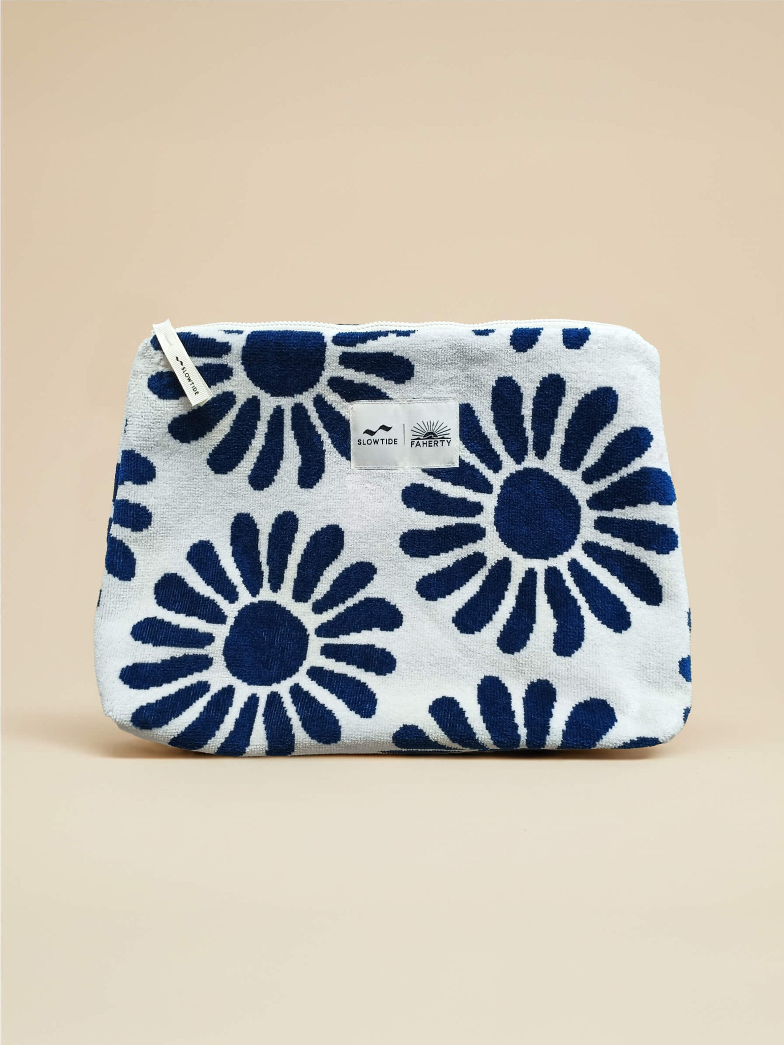 White pouch with blue floral pattern against a beige background