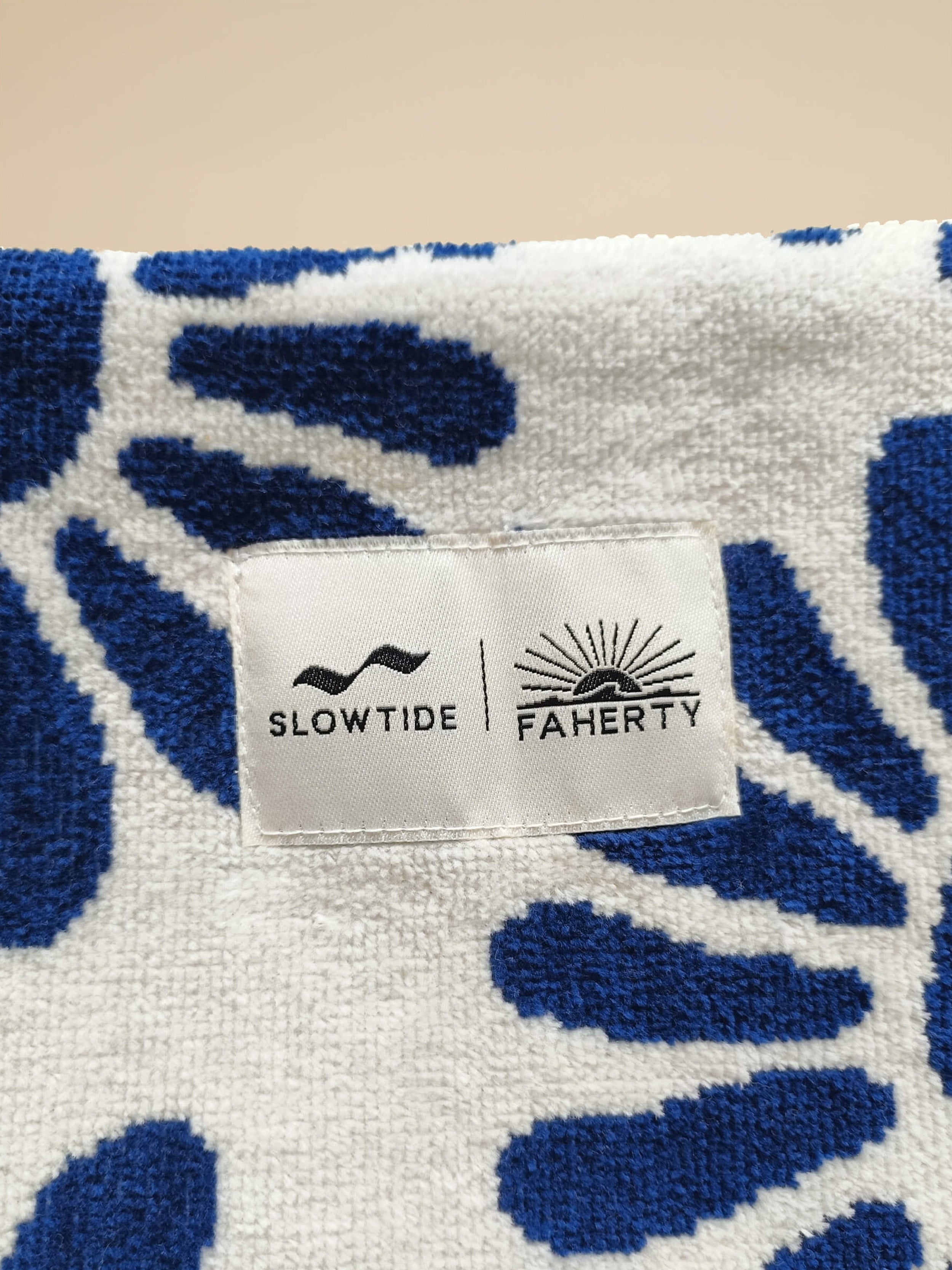 White pouch with blue floral pattern against a beige background