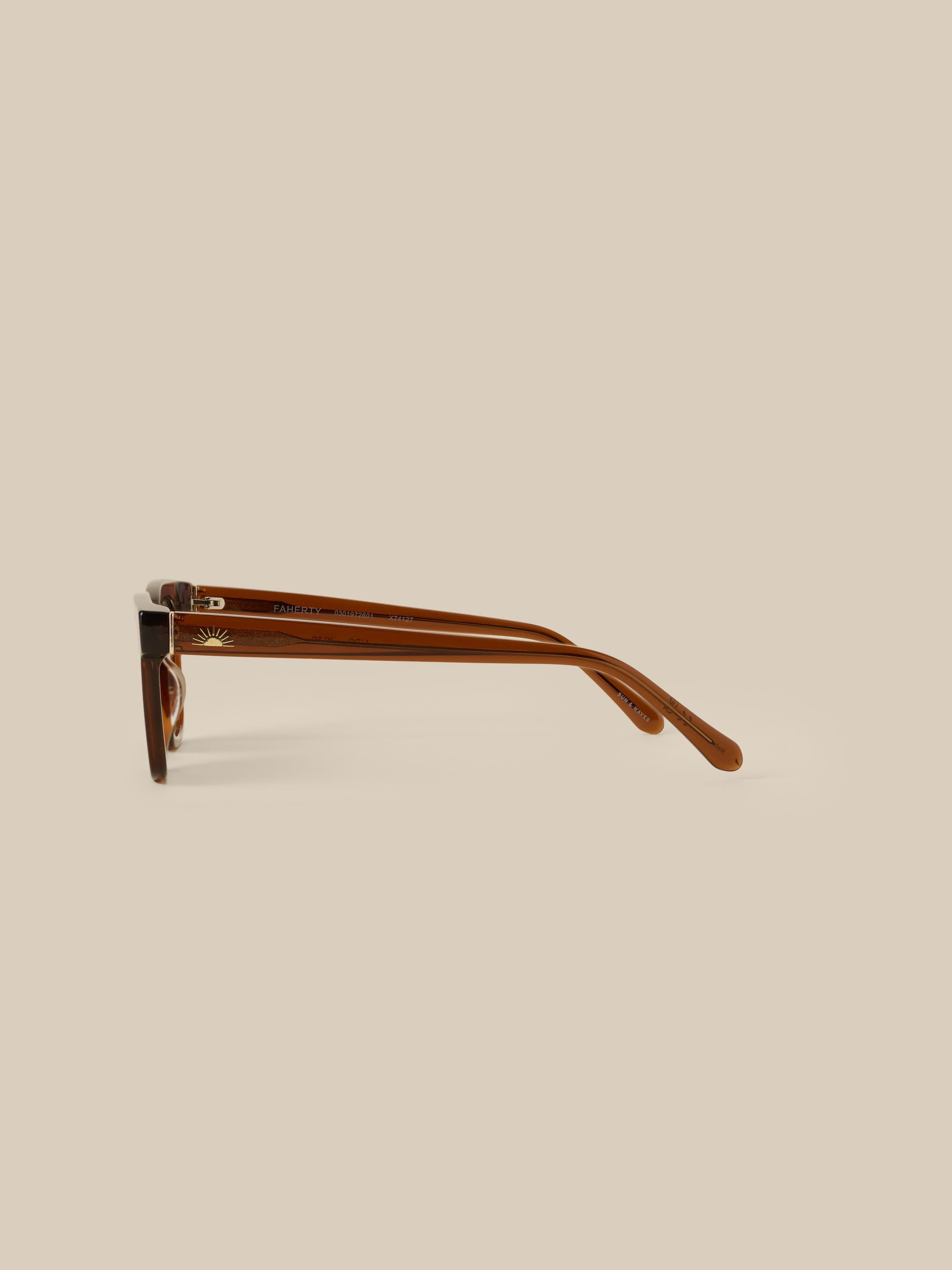 Brown sunglasses against a beige background