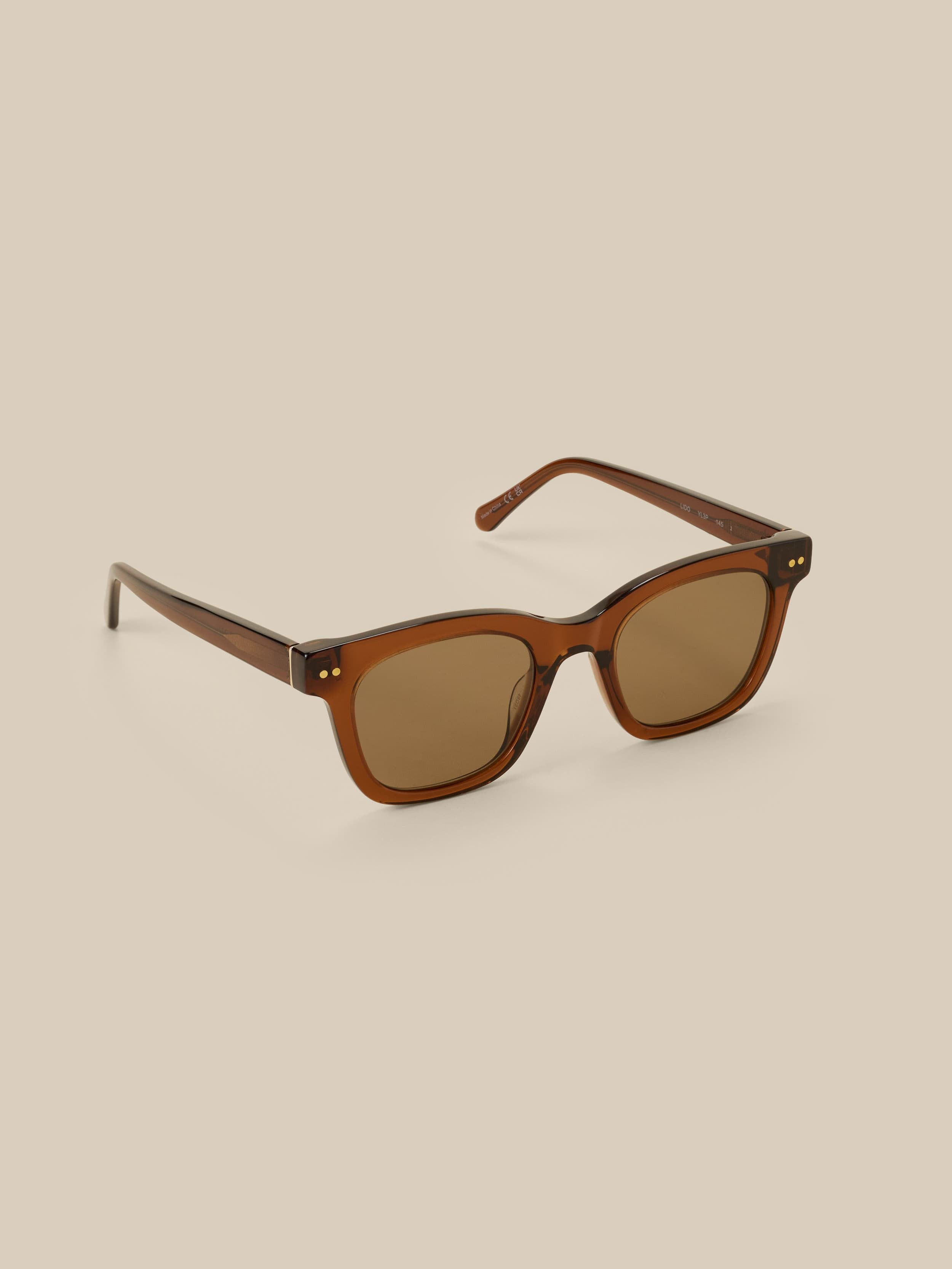 Brown sunglasses against a beige background