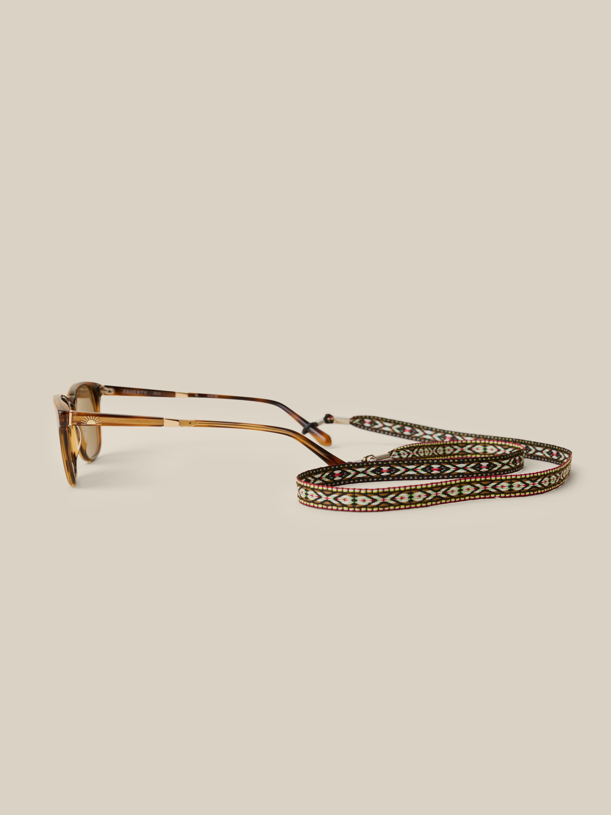 Glasses with a decorative strap on a beige background