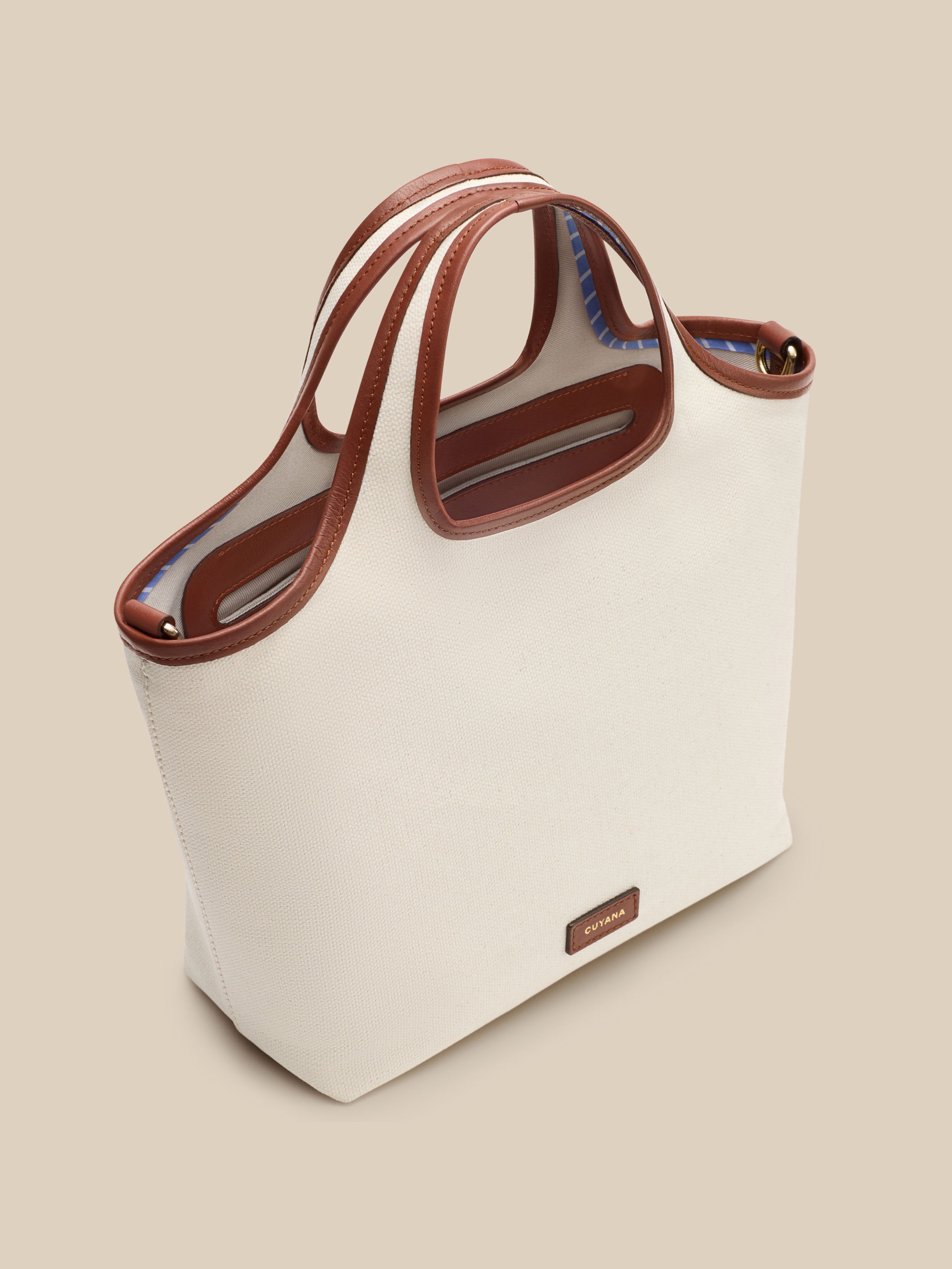 Beige canvas handbag with a beige interior on a beige background