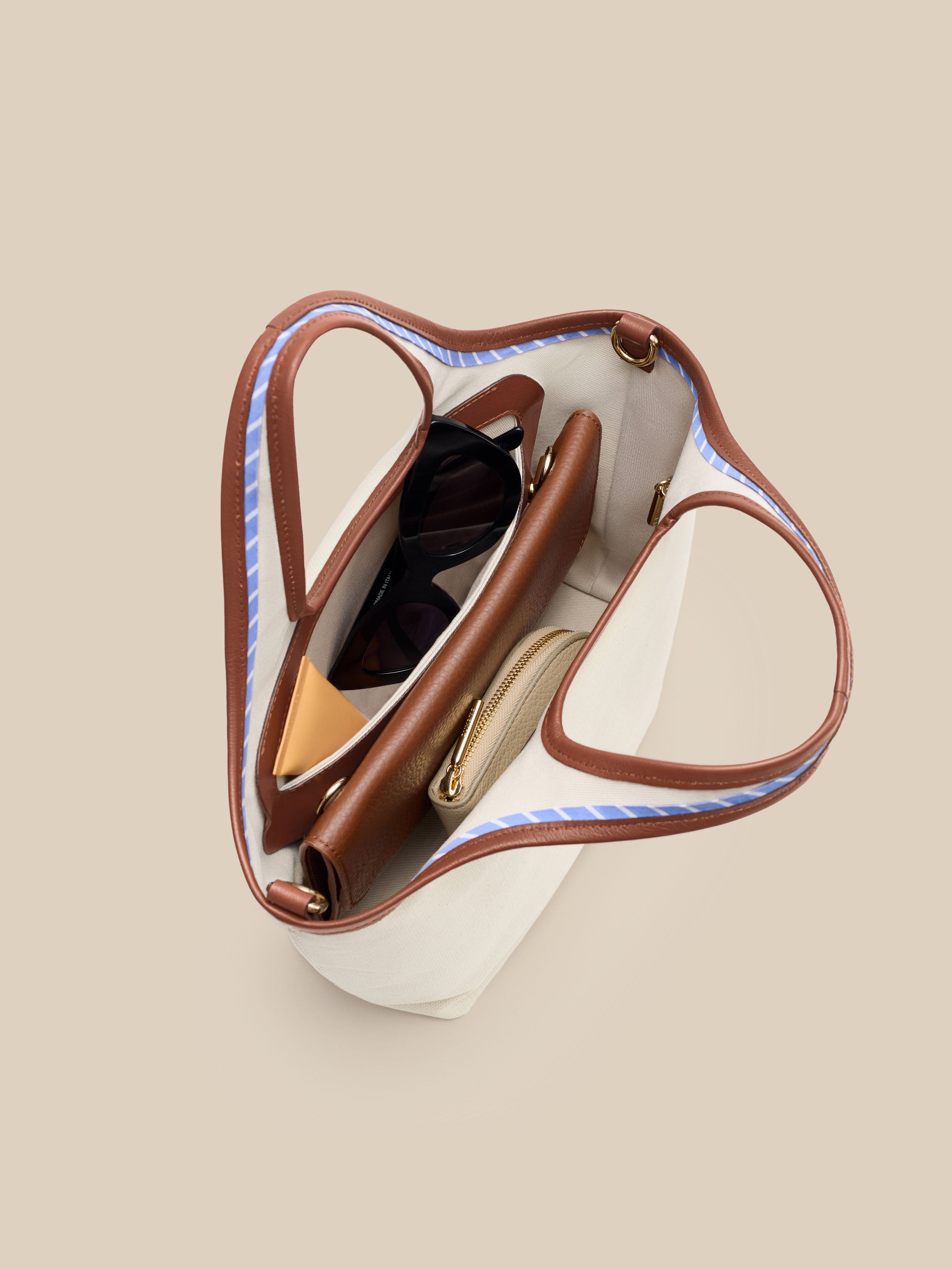Beige canvas handbag with a beige interior on a beige background