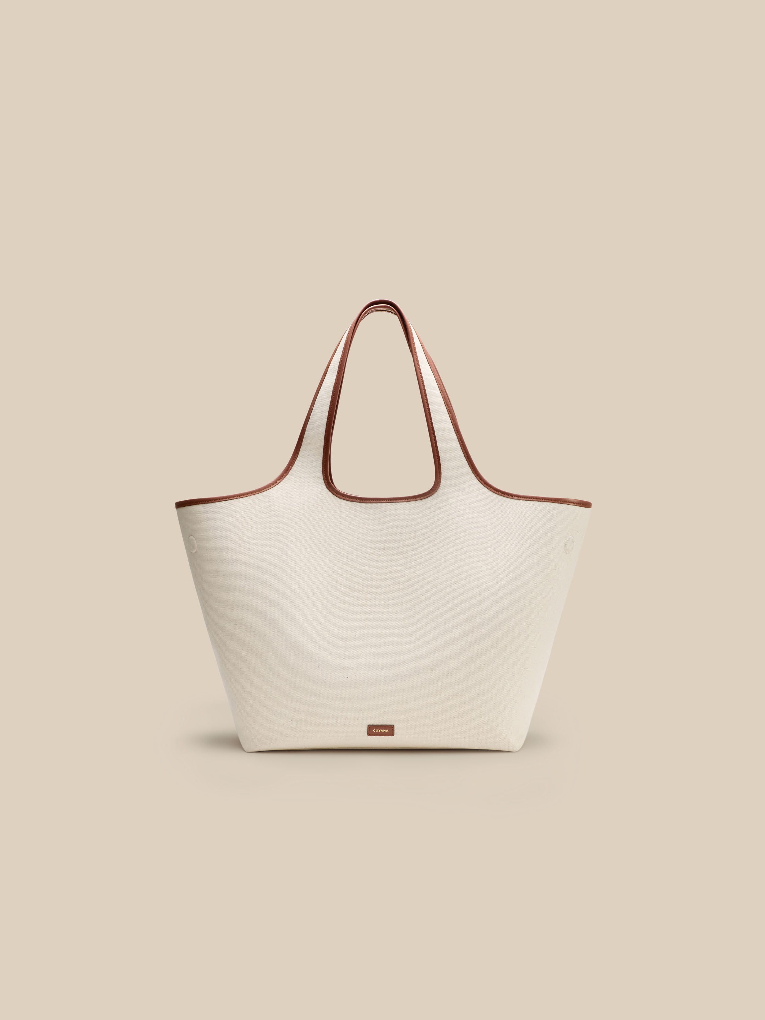 Beige canvas handbag with a beige interior on a beige background