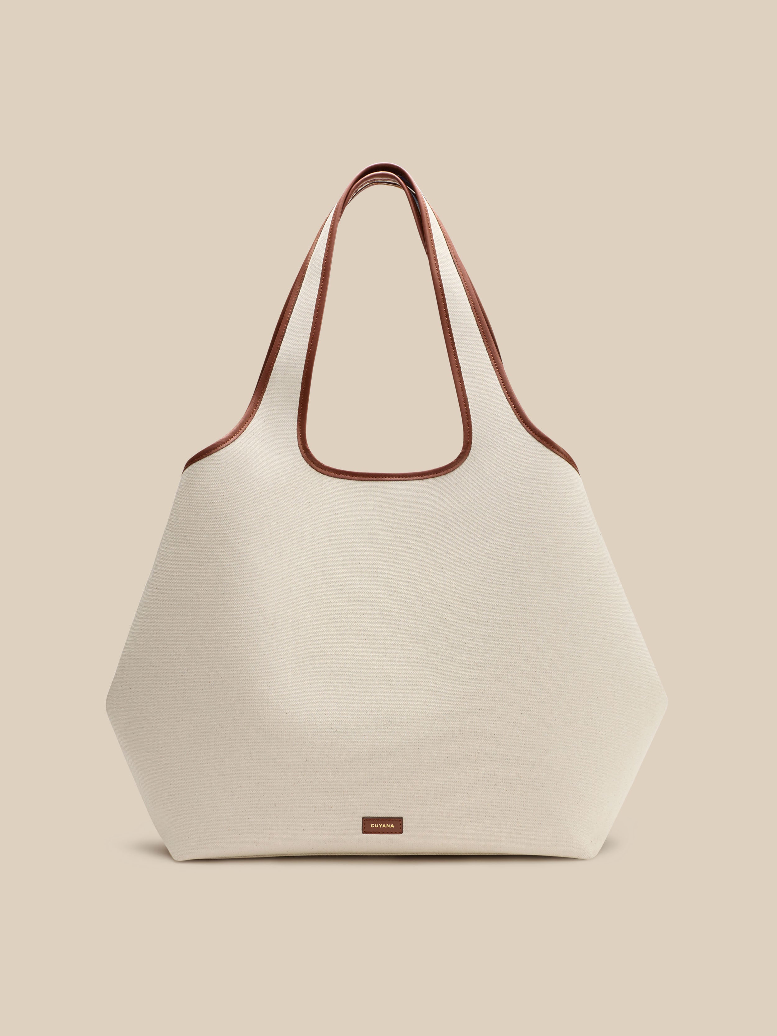 Beige canvas handbag with a beige interior on a beige background