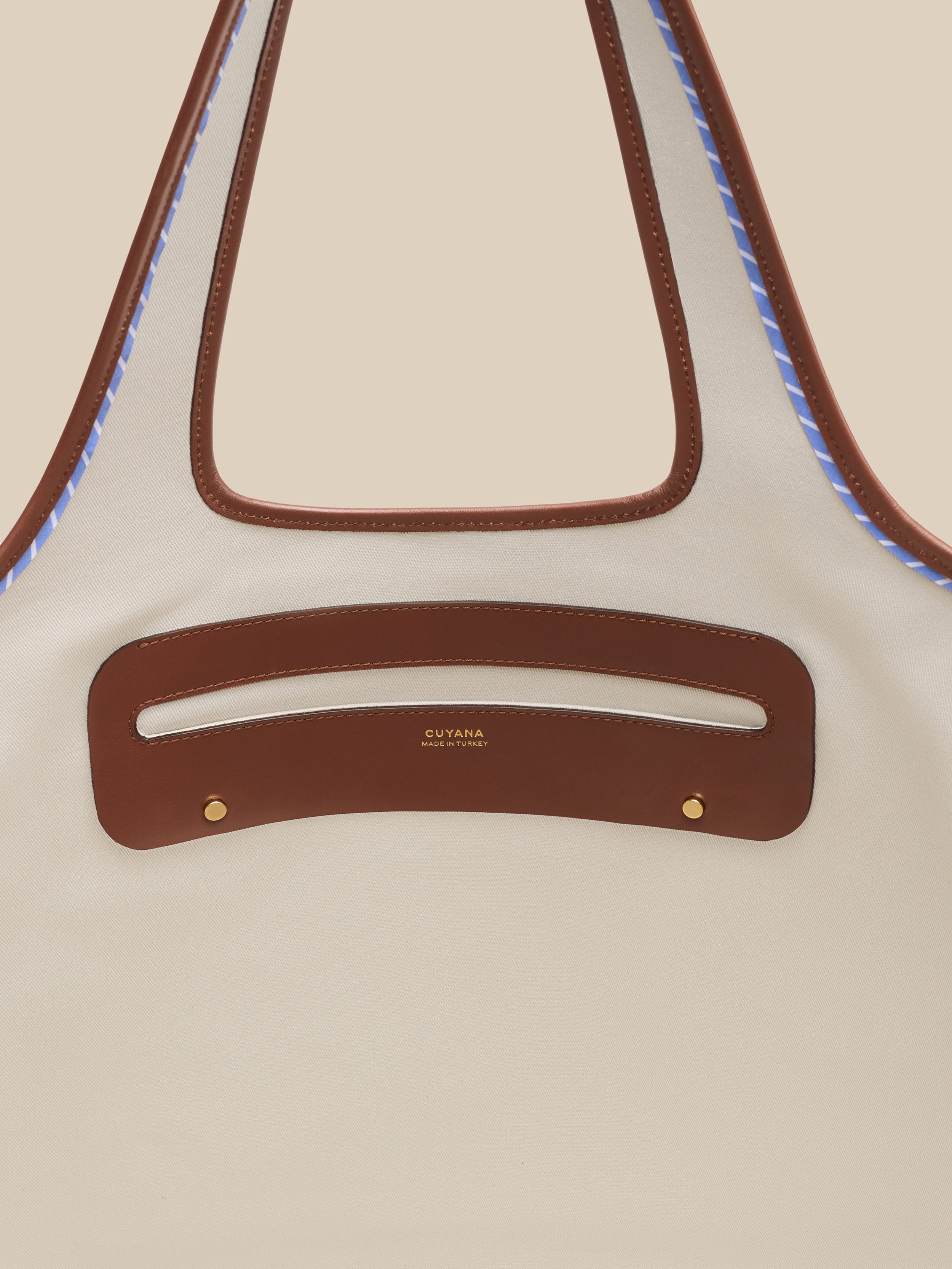 Beige canvas handbag with a beige interior on a beige background