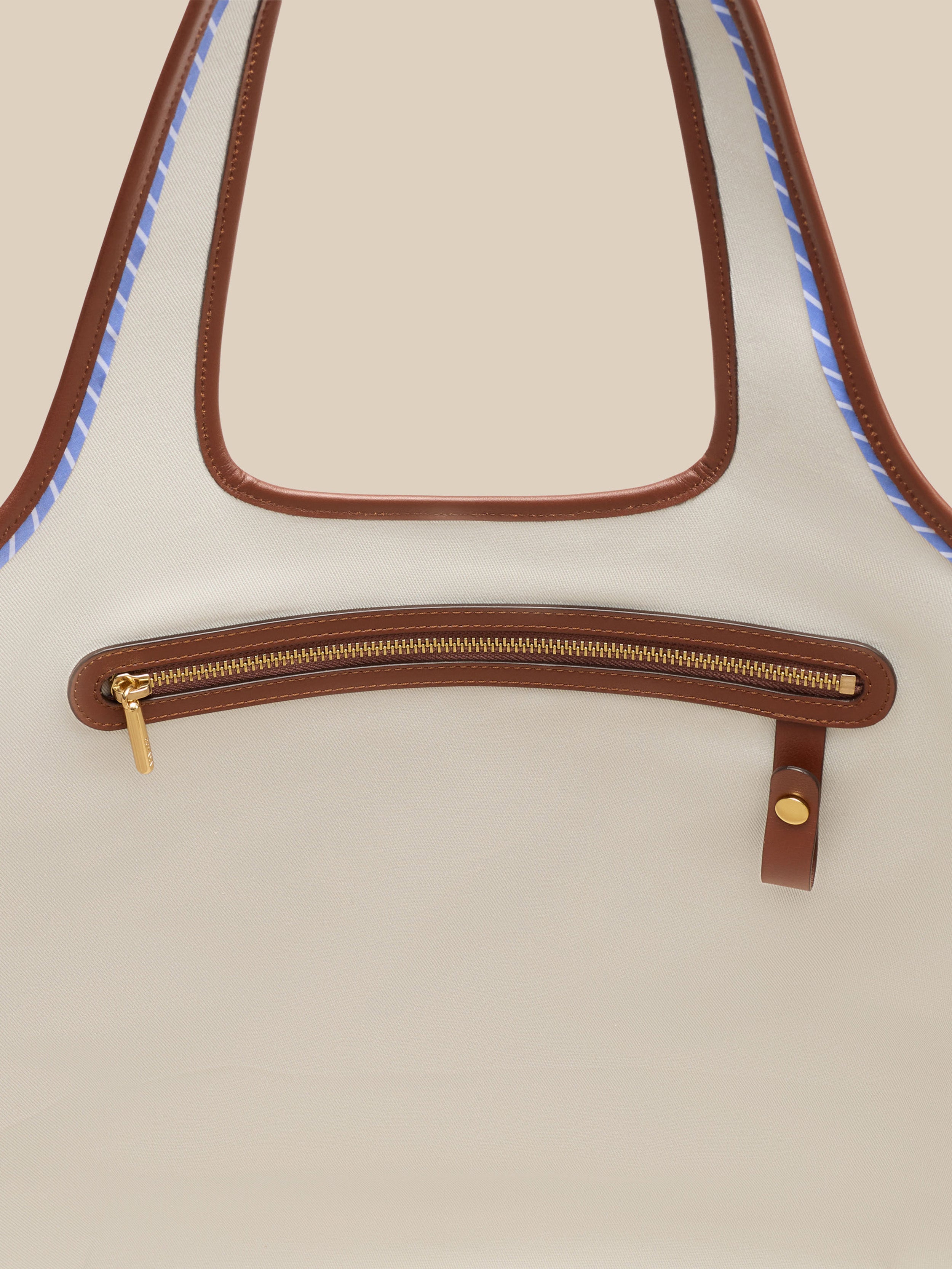 Beige canvas handbag with a beige interior on a beige background