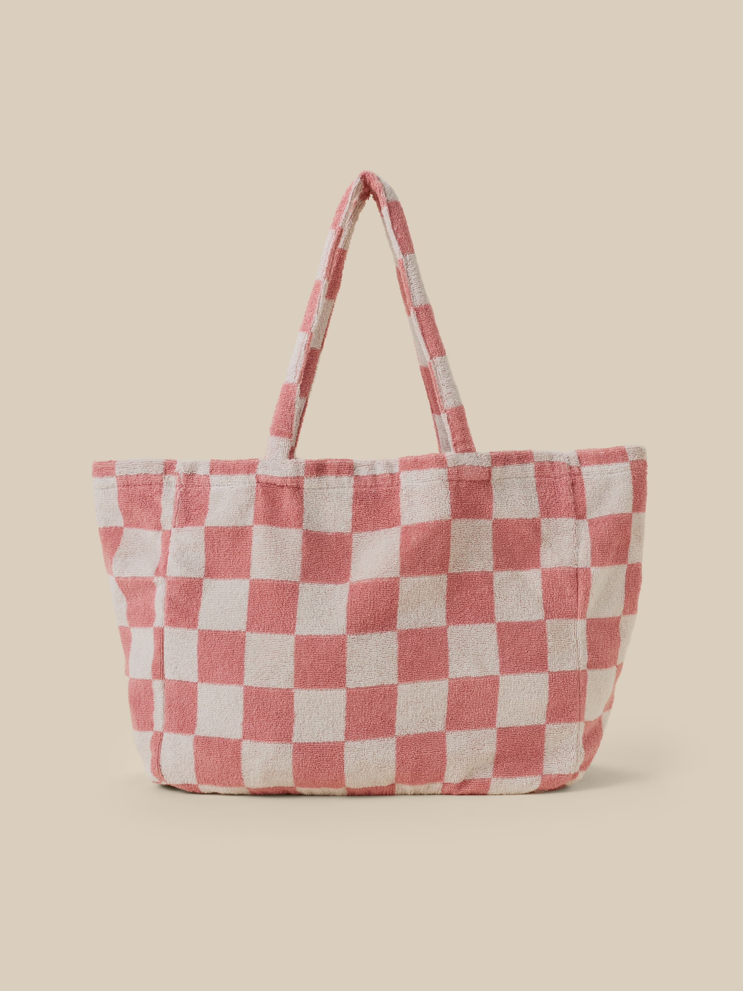 Checkered tote bag with red and white pattern on a beige background