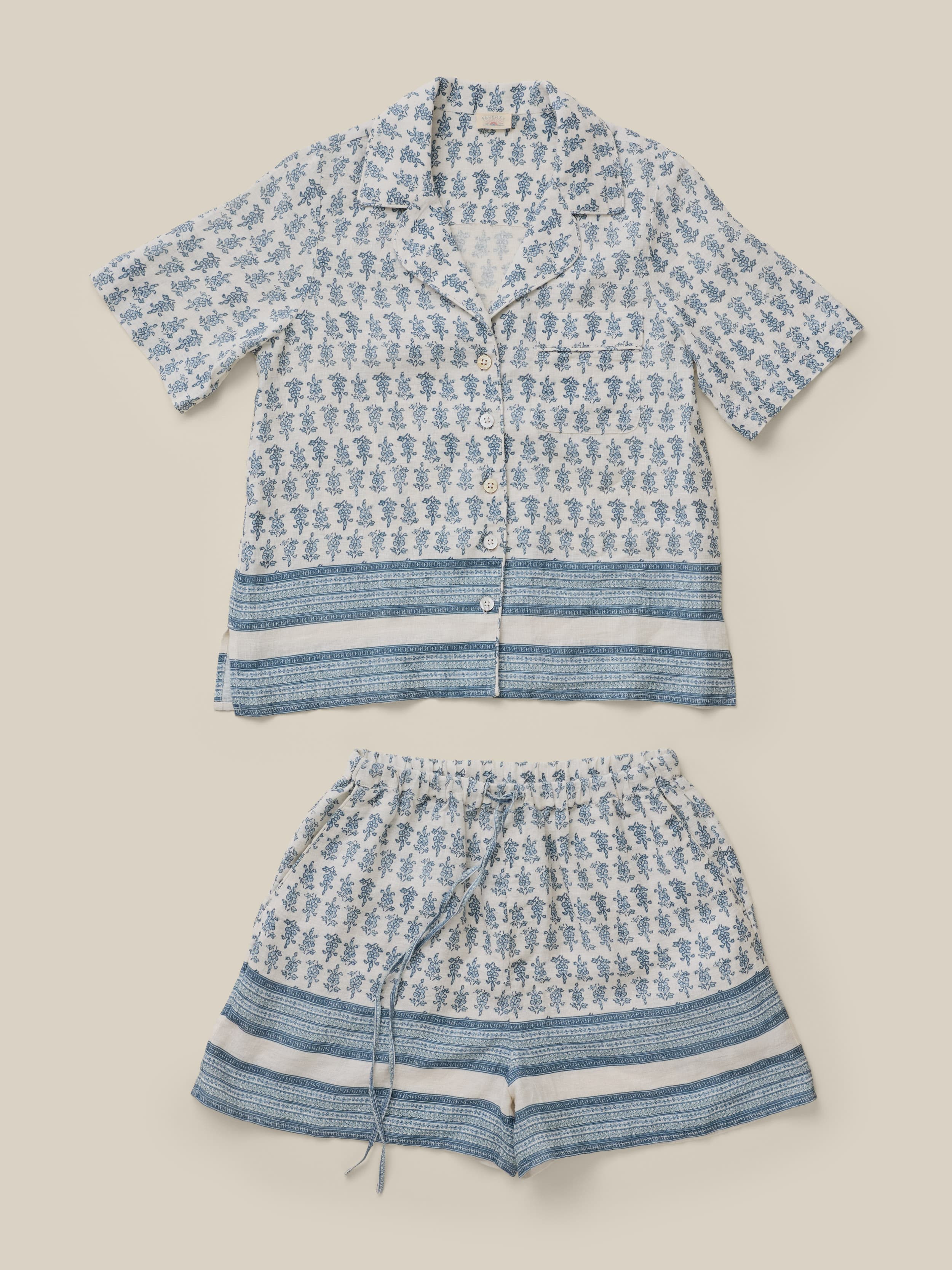 Blue and white patterned shirt and shorts set on a beige background