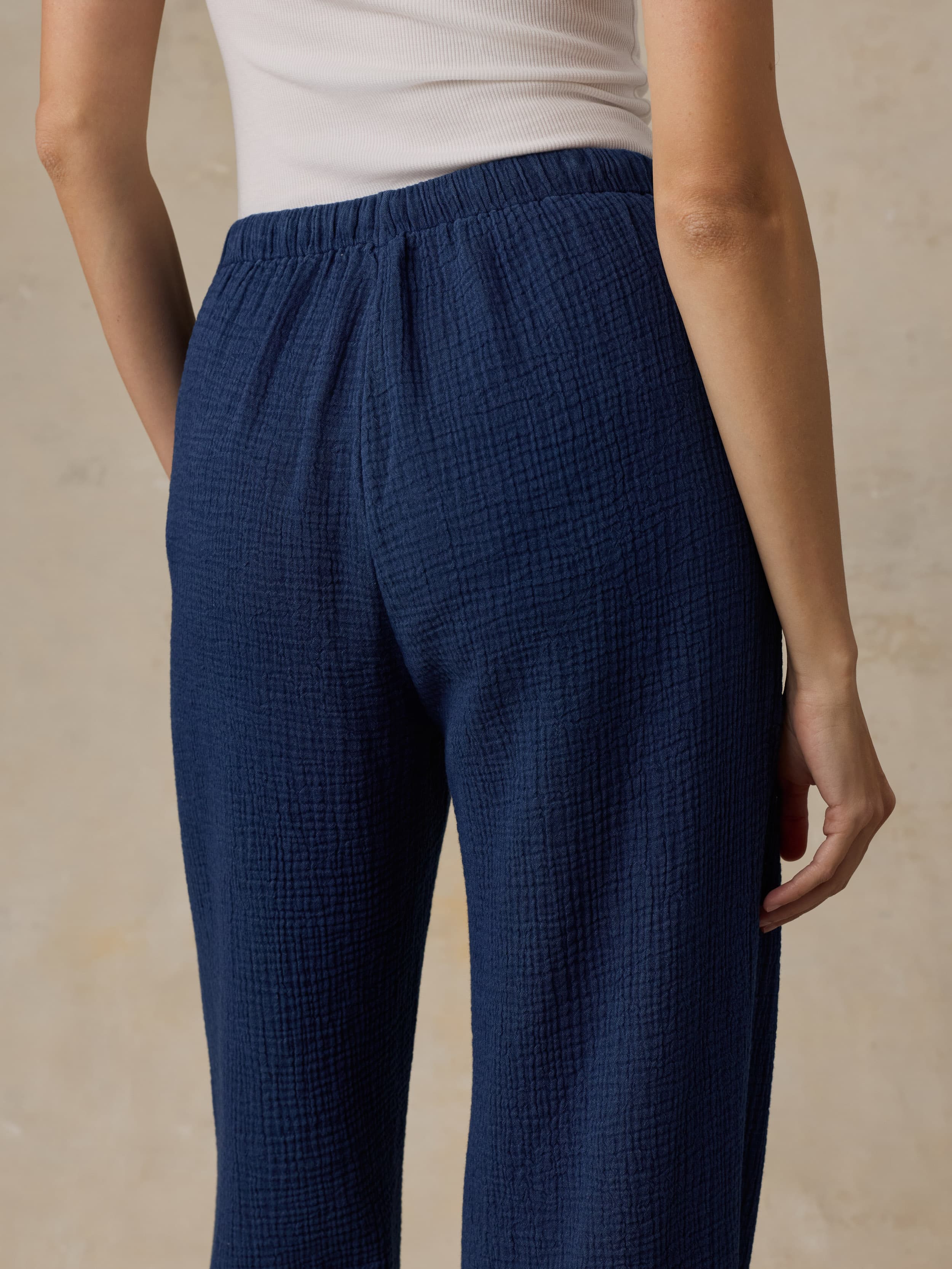 Woman wearing blue pants on a beige background