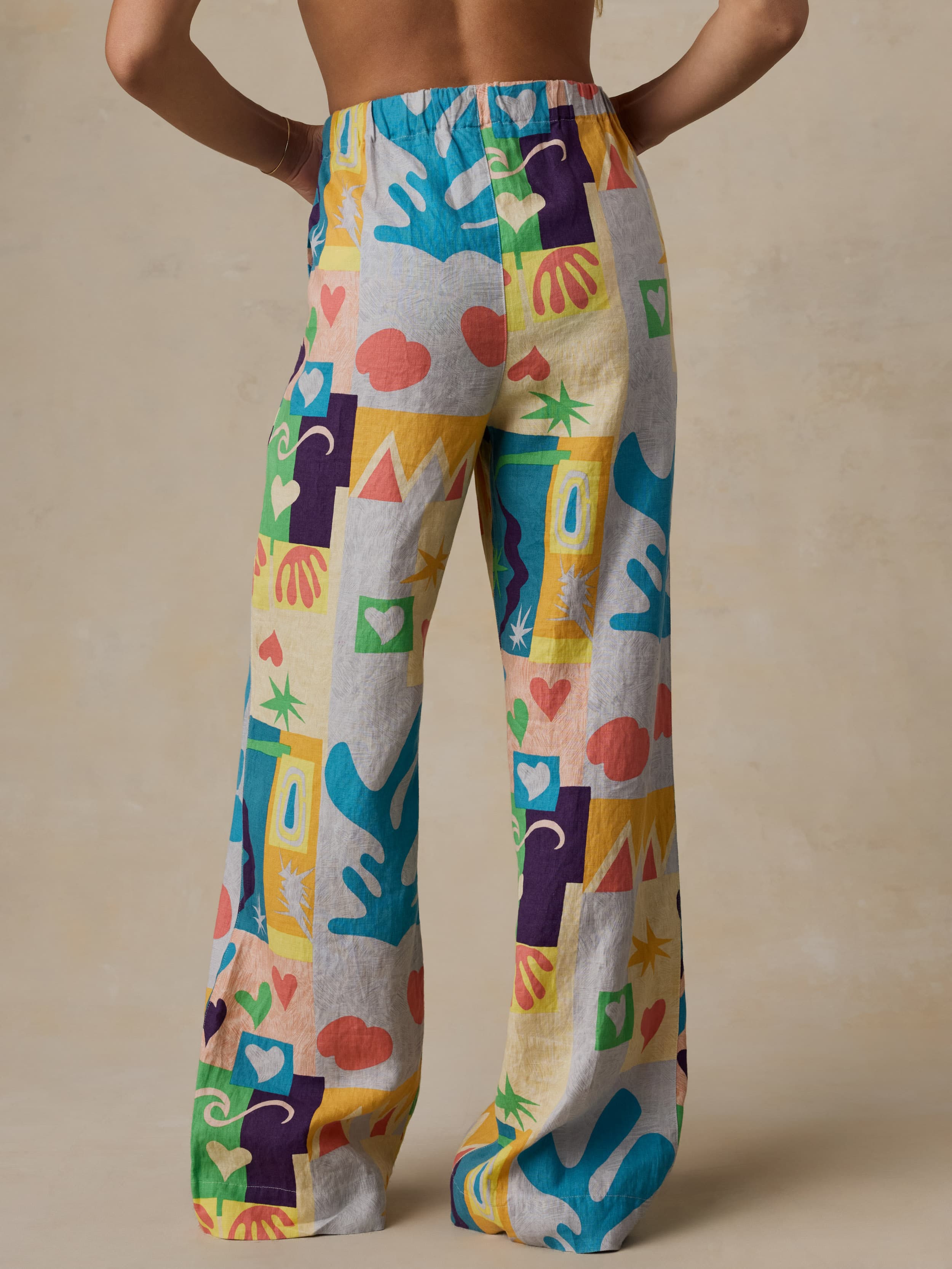 Colorful patterned pants worn by a woman on a beige background