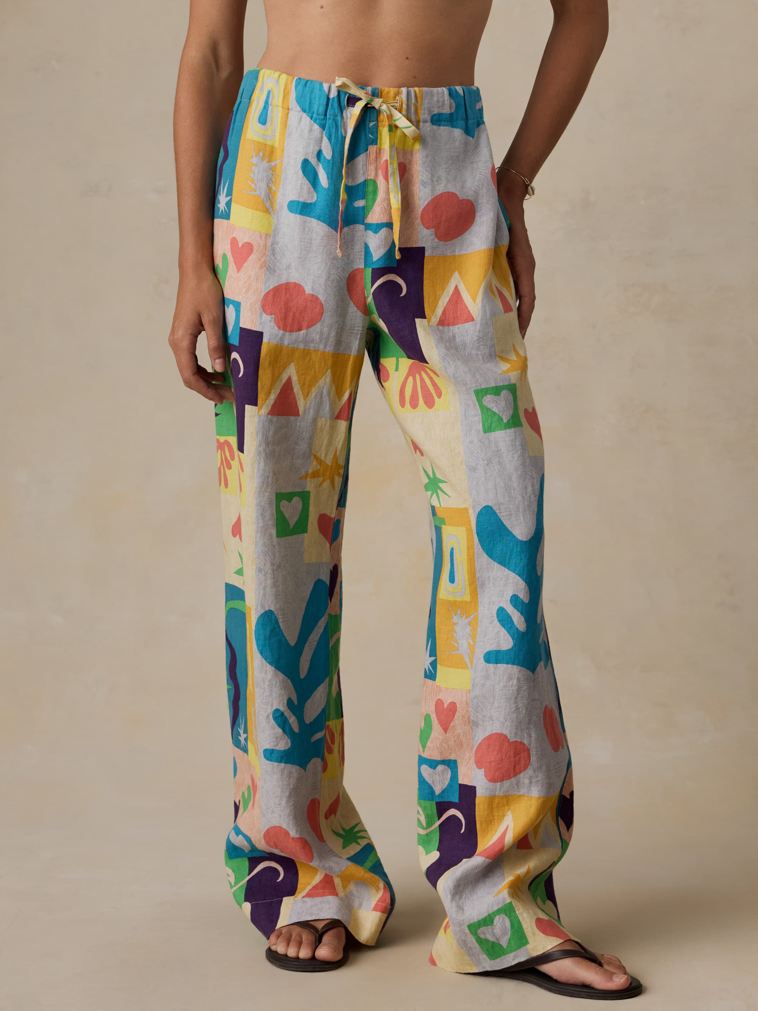Woman wearing colorful printed pants against a beige background
