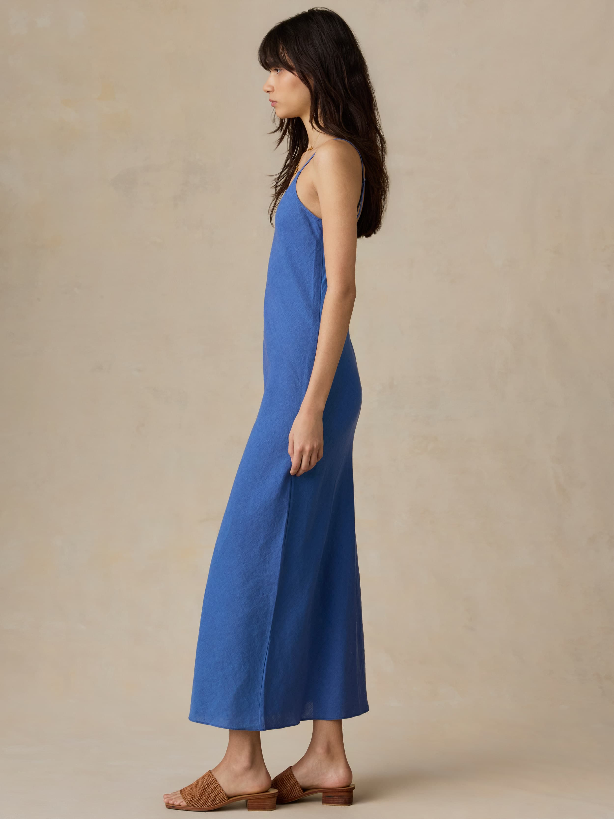 Woman wearing a blue dress against a beige background