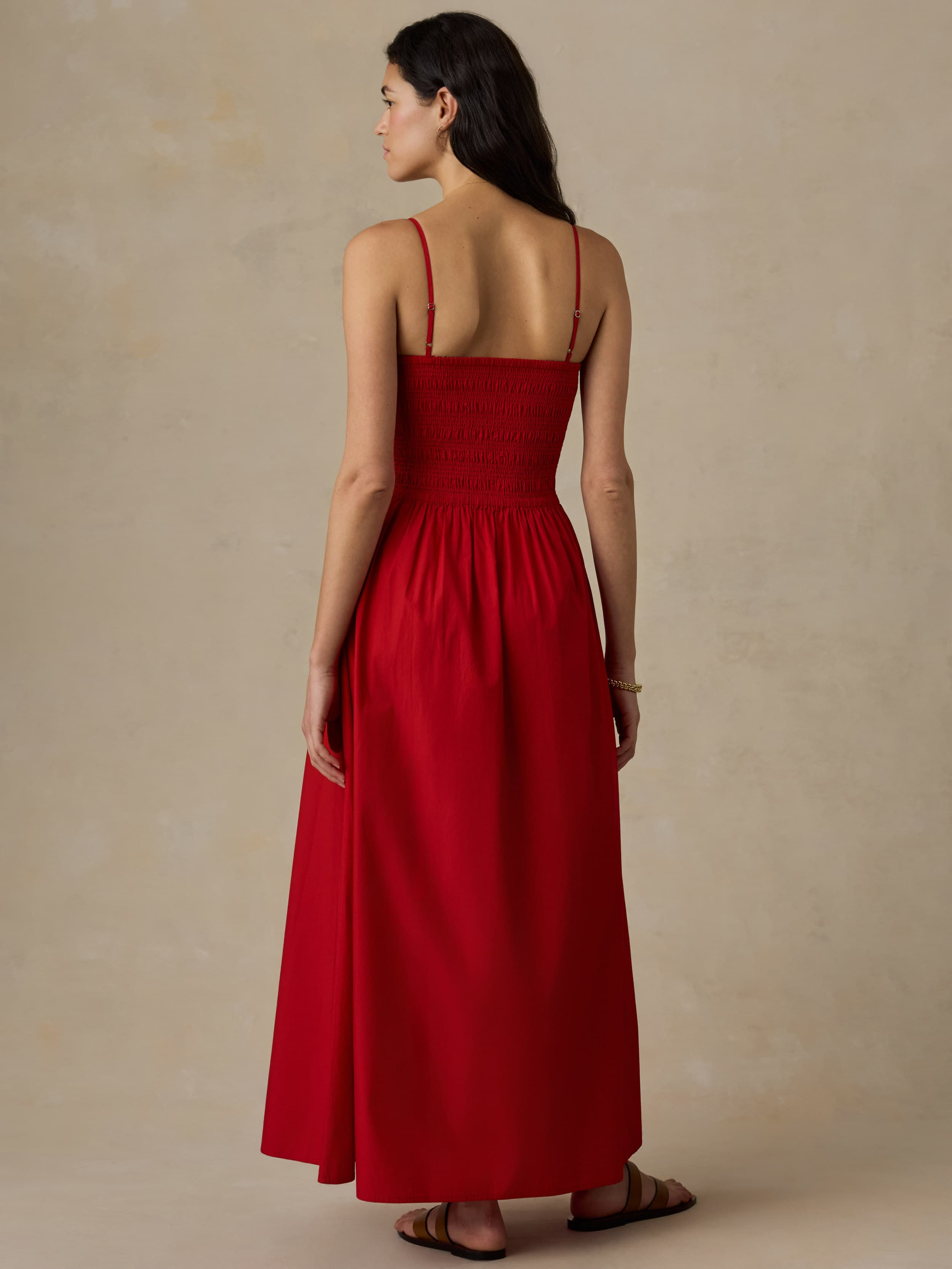 Woman wearing a red dress against a beige background